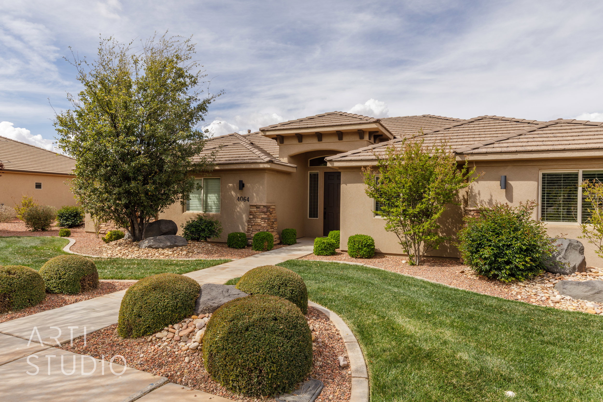 Stucco exterior with stone accents and a terracotta-tiled roof