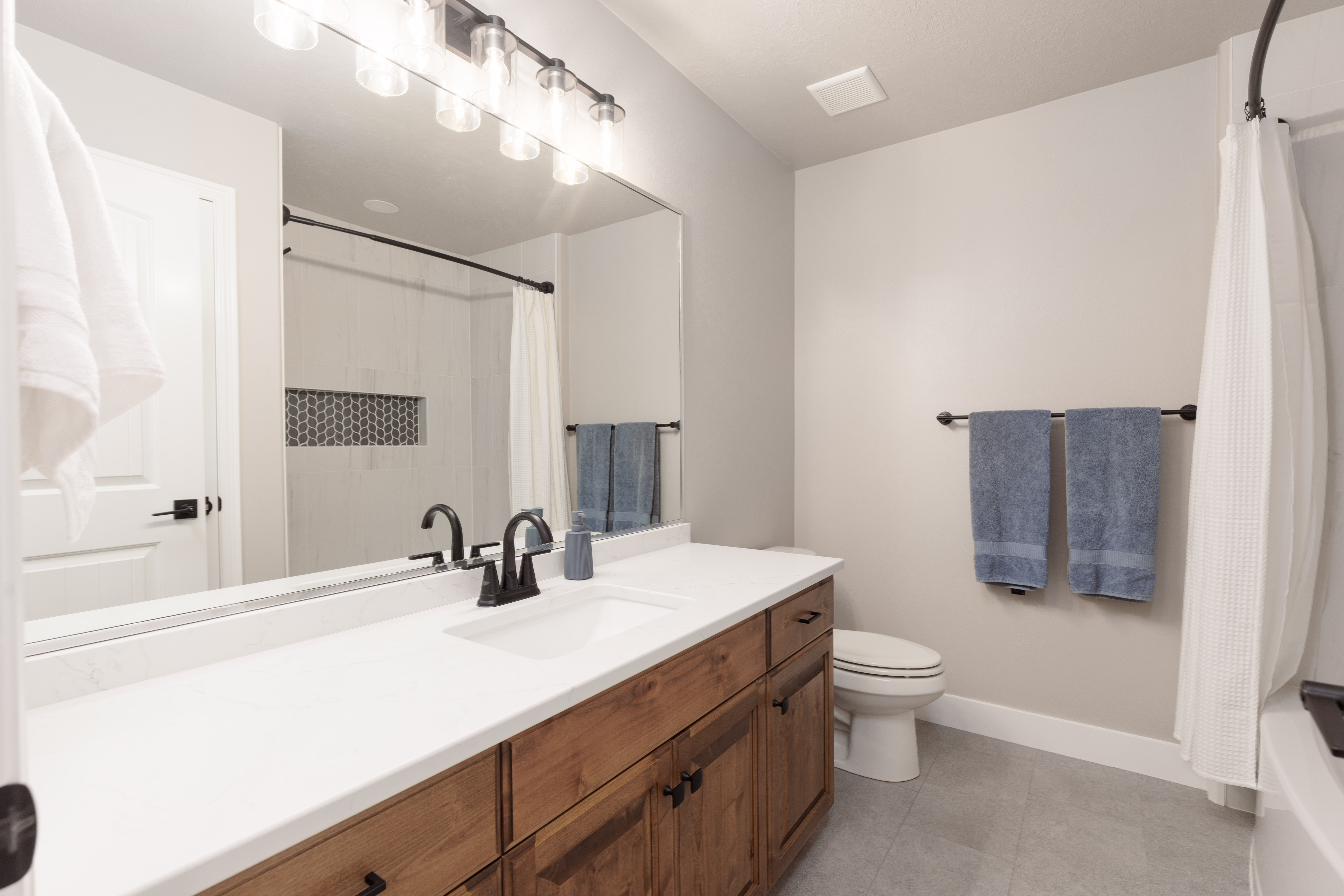 Extra long vanity with a white countertop and wood-finish cabinetry