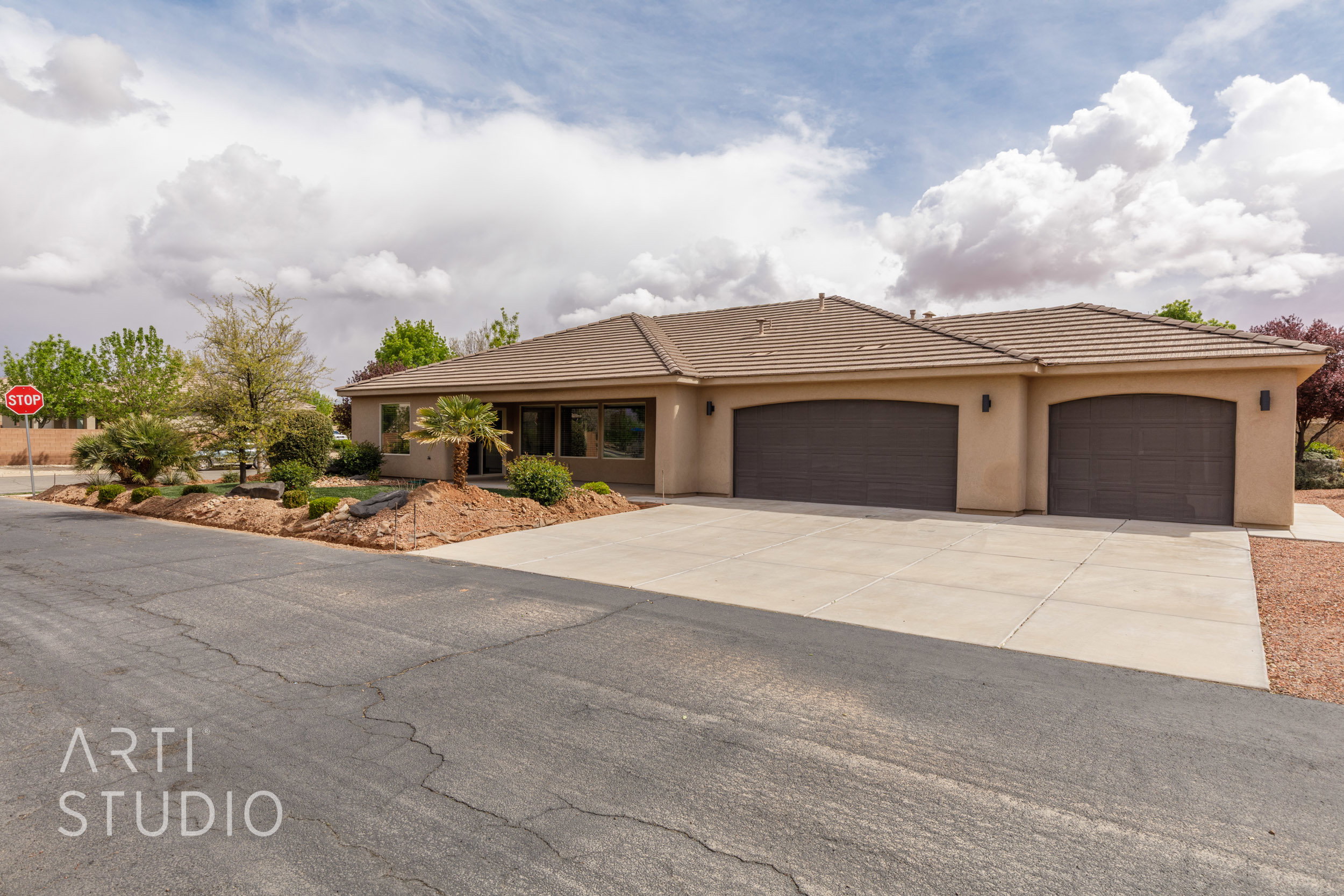 Single-story residence featuring a tan stucco exterior and a multi-car concrete driveway and RV parking.