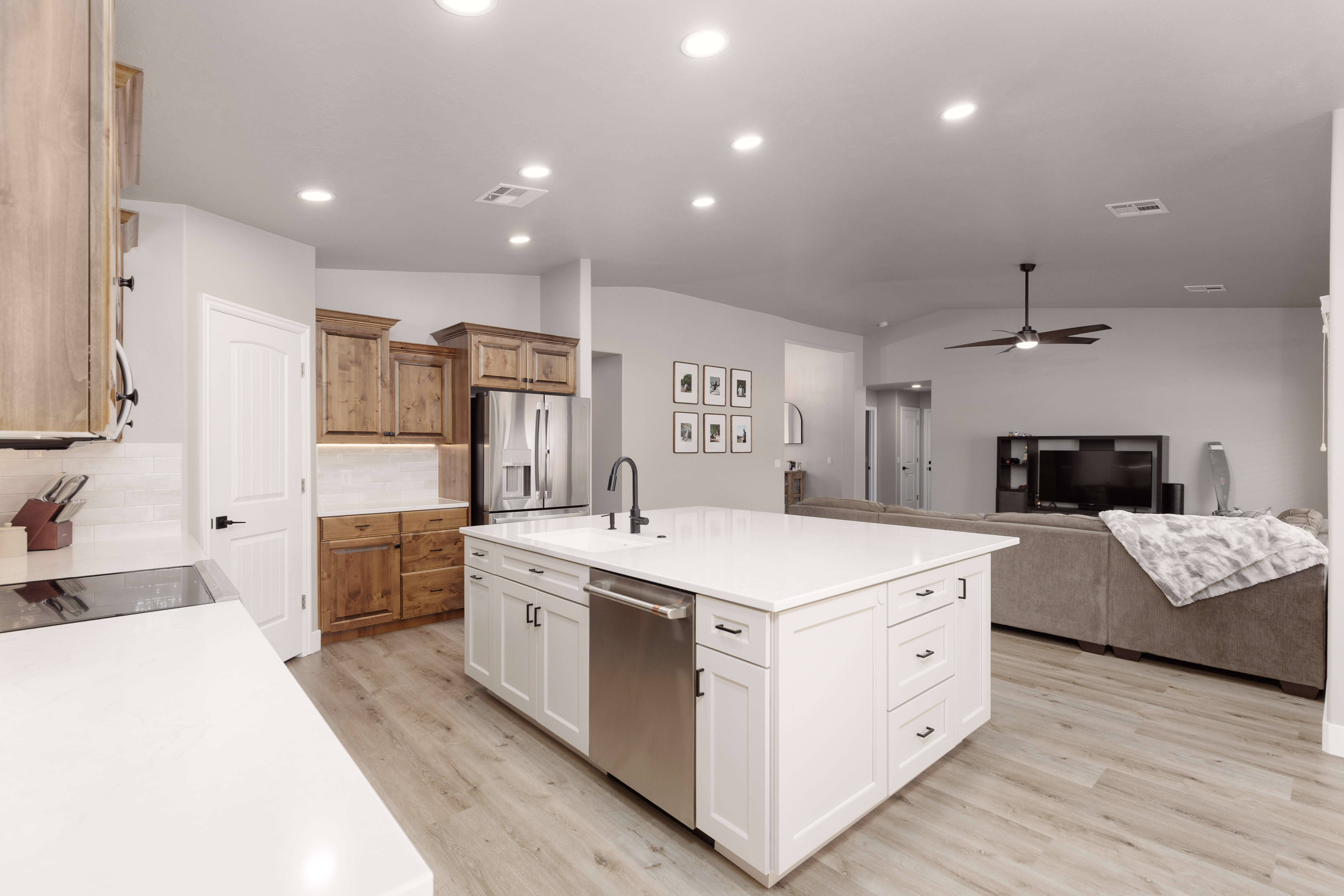 Modern kitchen featuring a large central island with white cabinetry and a built-in stainless steel dishwasher