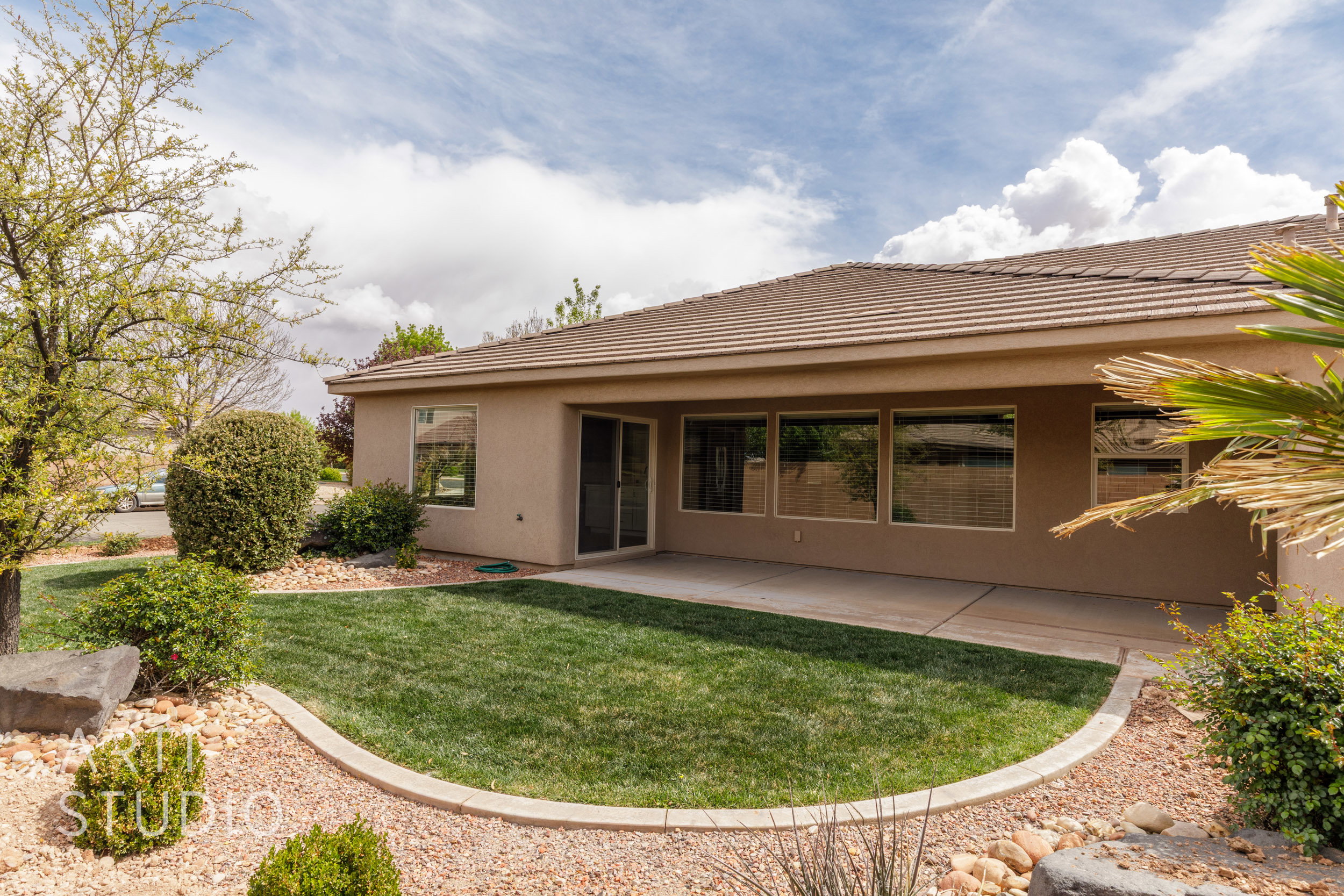 Large covered patio with exterior lighting. Backyard has been enclosed with a block wall.
