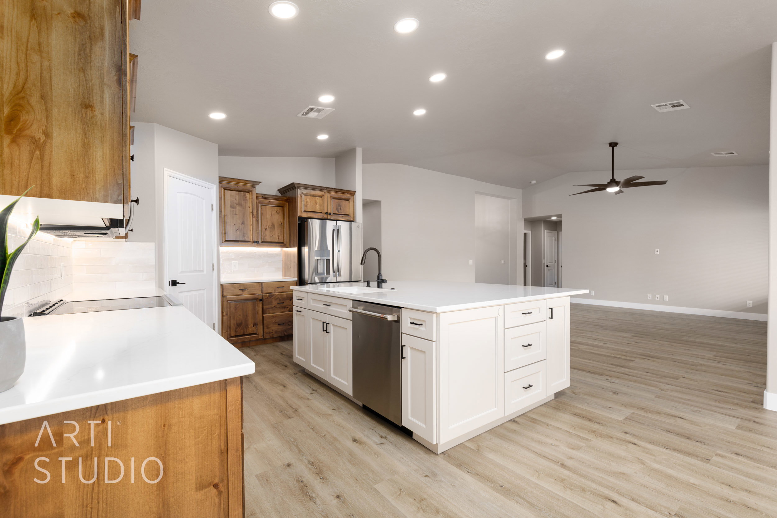 Modern kitchen featuring a large central island with white cabinetry and a built-in stainless steel dishwasher