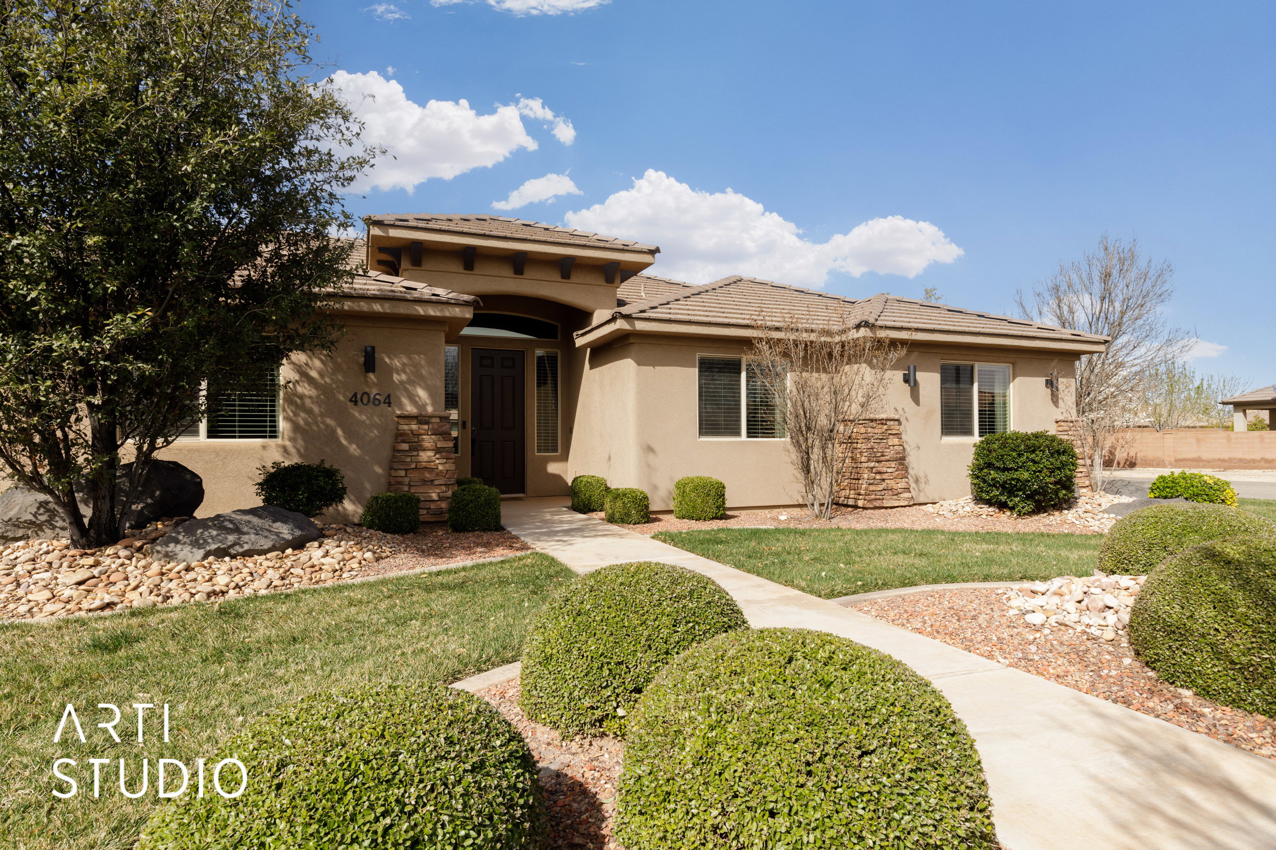 Stucco exterior with stone accents and a terracotta tile roof