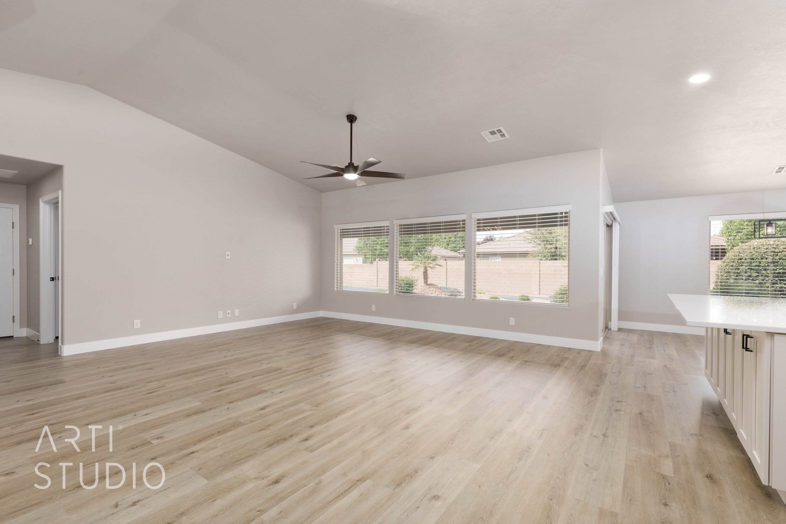Spacious interior featuring new LVP flooring, vaulted ceilings, and a modern ceiling fan