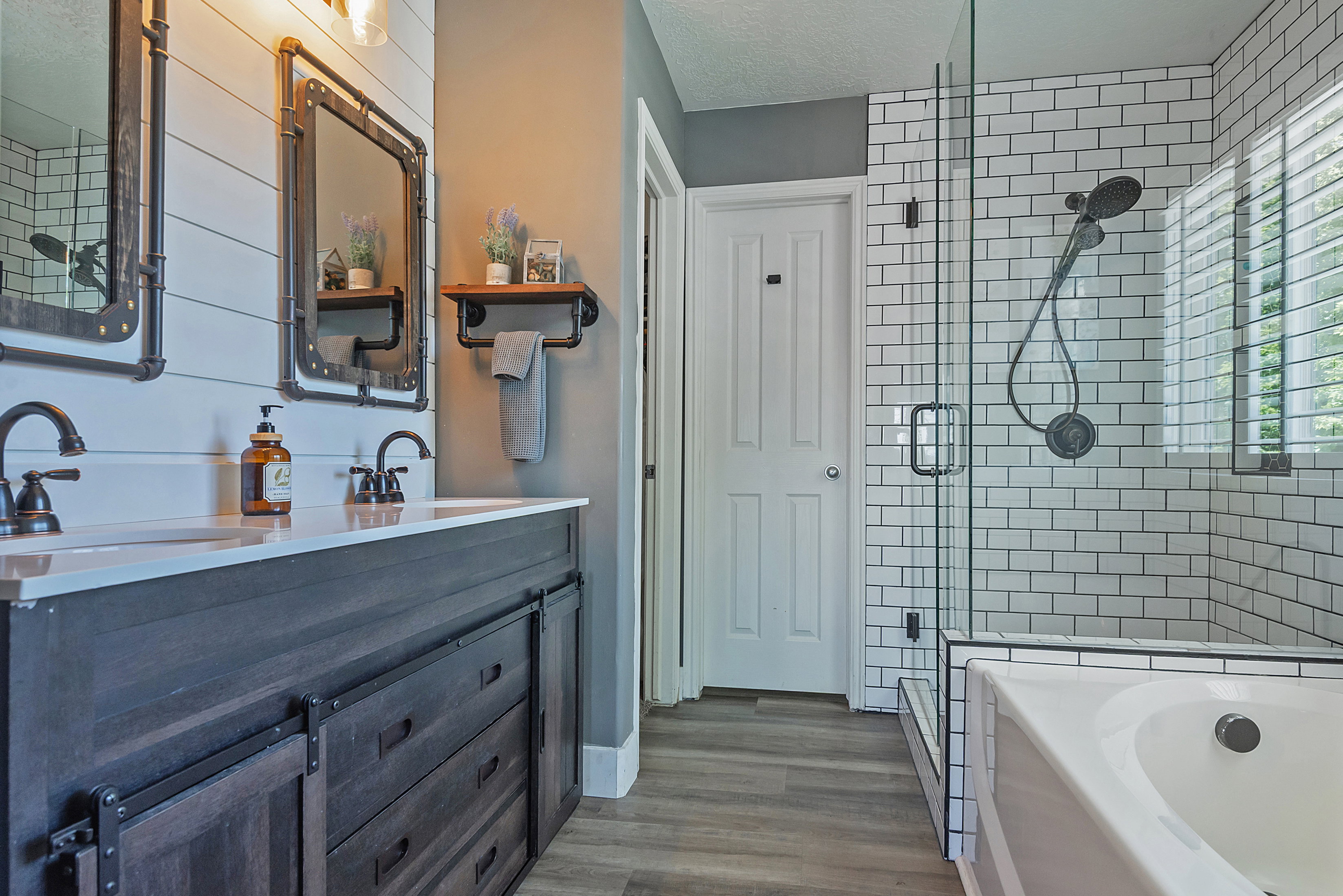 Bathroom featuring a double vanity with dark wood-finish cabinetry, white countertops, and dual basin sinks