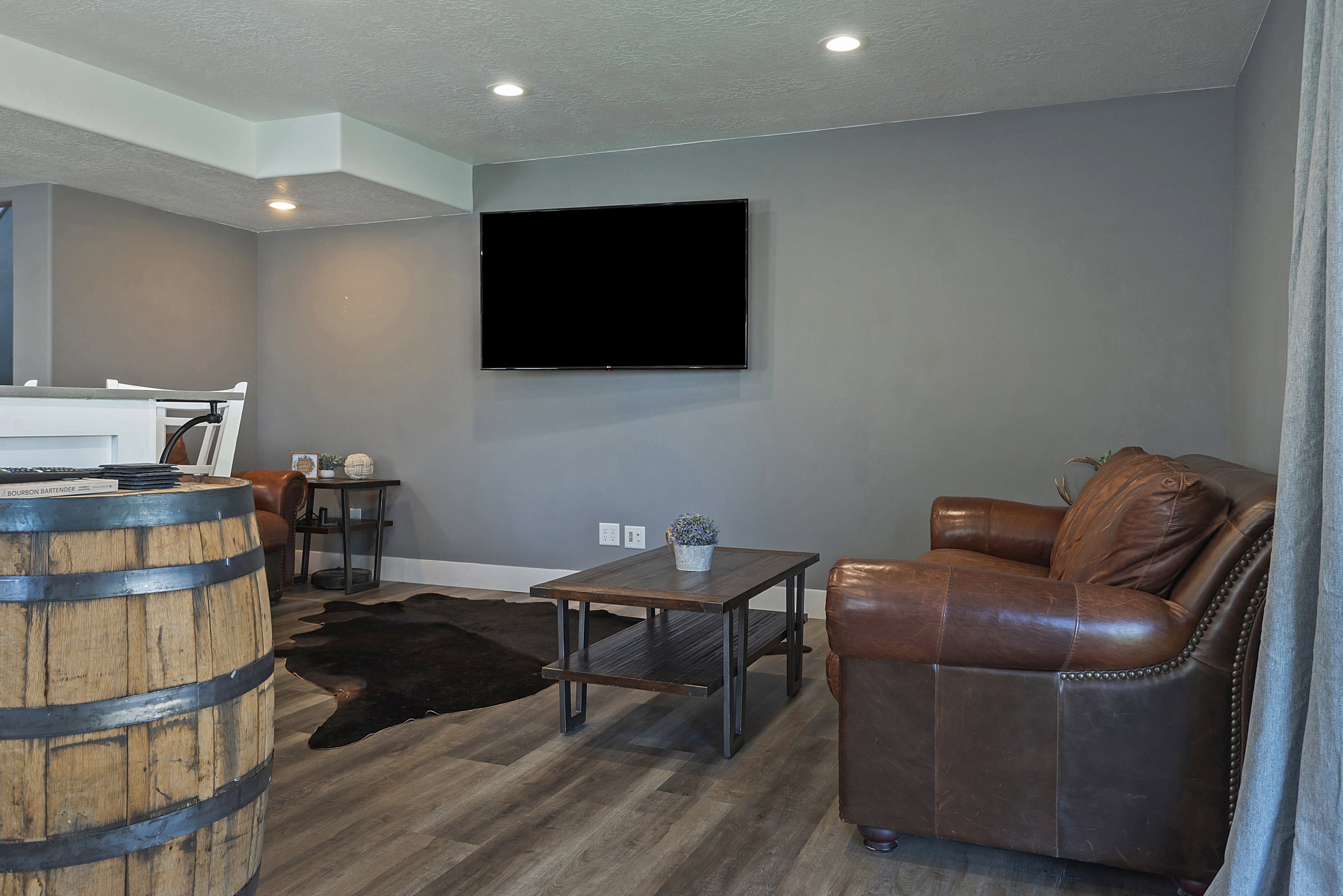 Entertainment space with recessed lighting and wood-finish flooring