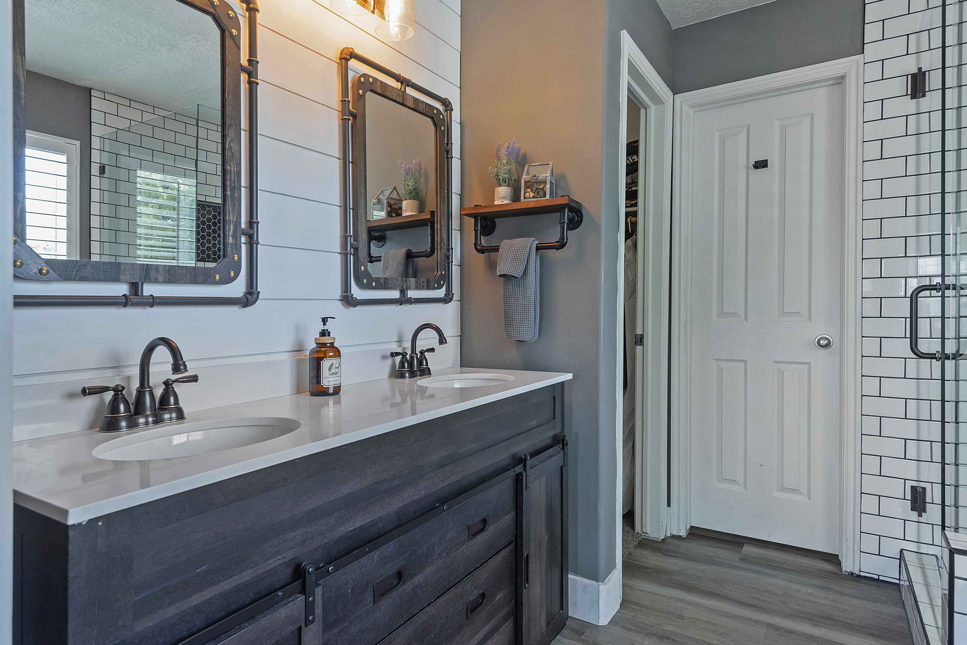 Dual vanity with dark wood-finish cabinetry, white countertop, and matte black fixtures