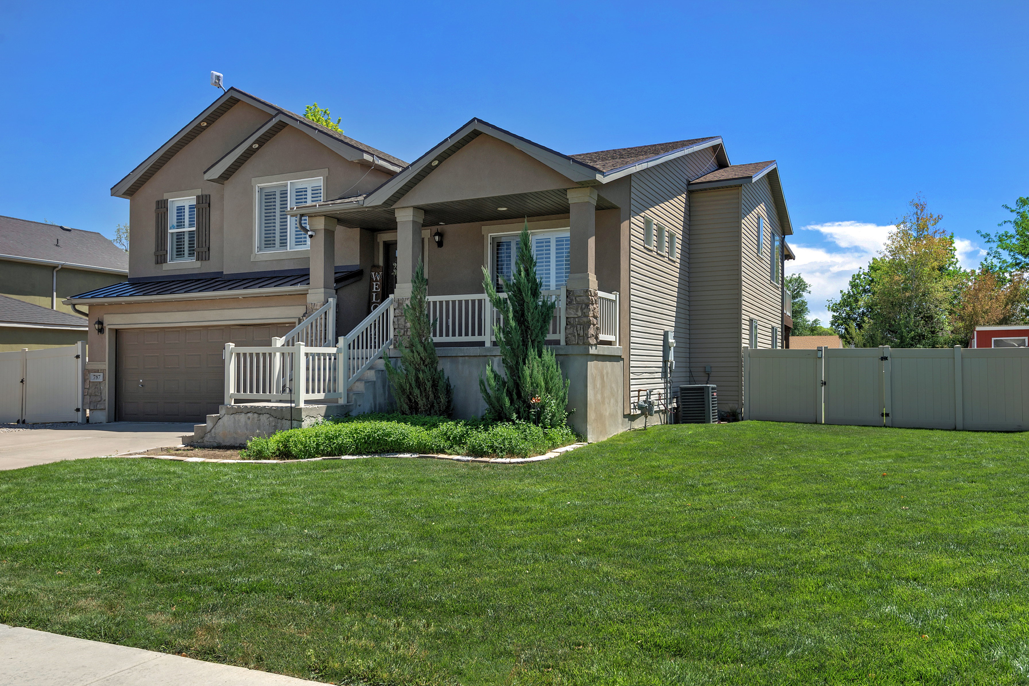 Two-story property featuring a stucco and siding exterior, an attached garage, and a covered porch