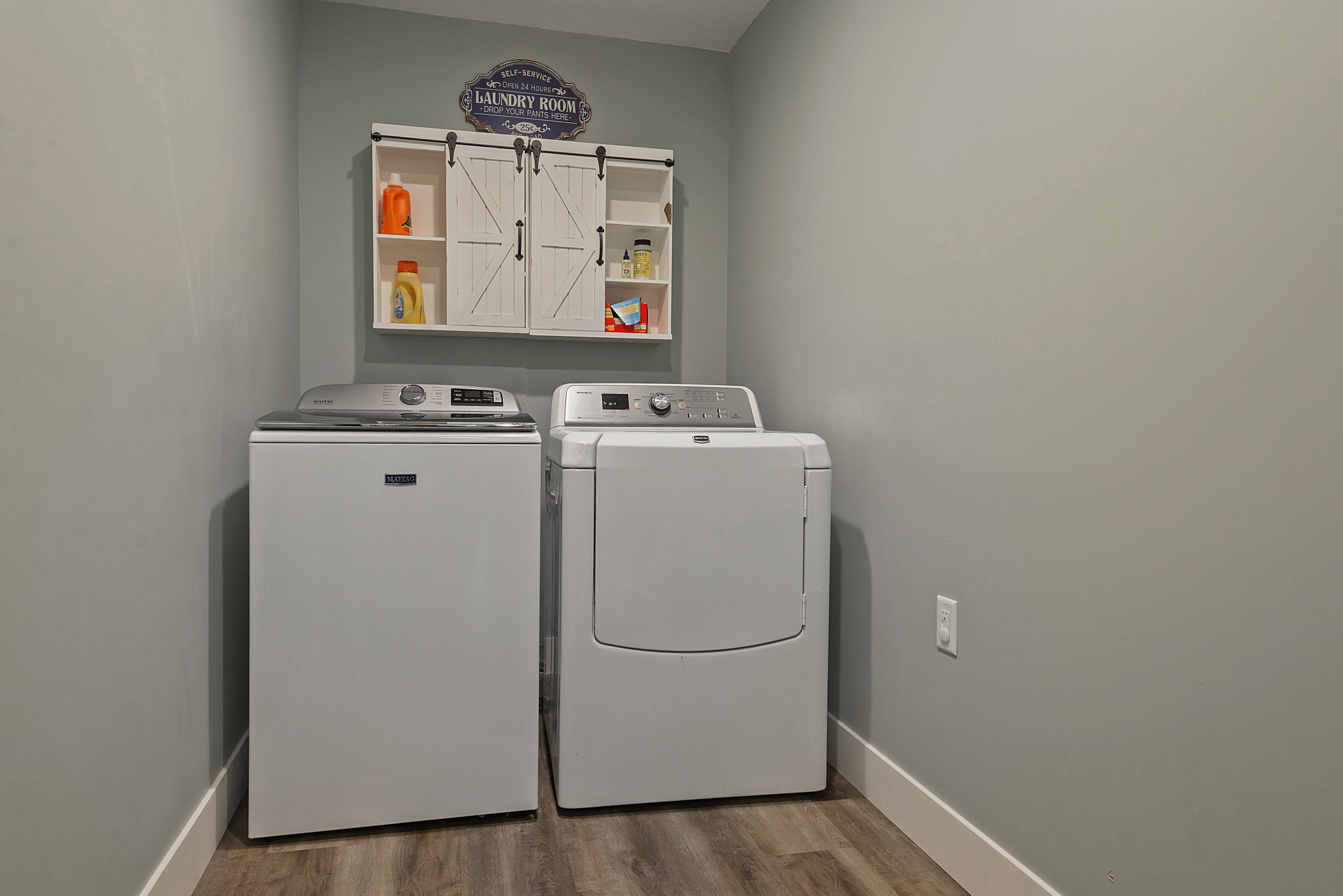 Dedicated laundry area featuring wood-finish flooring and light gray walls