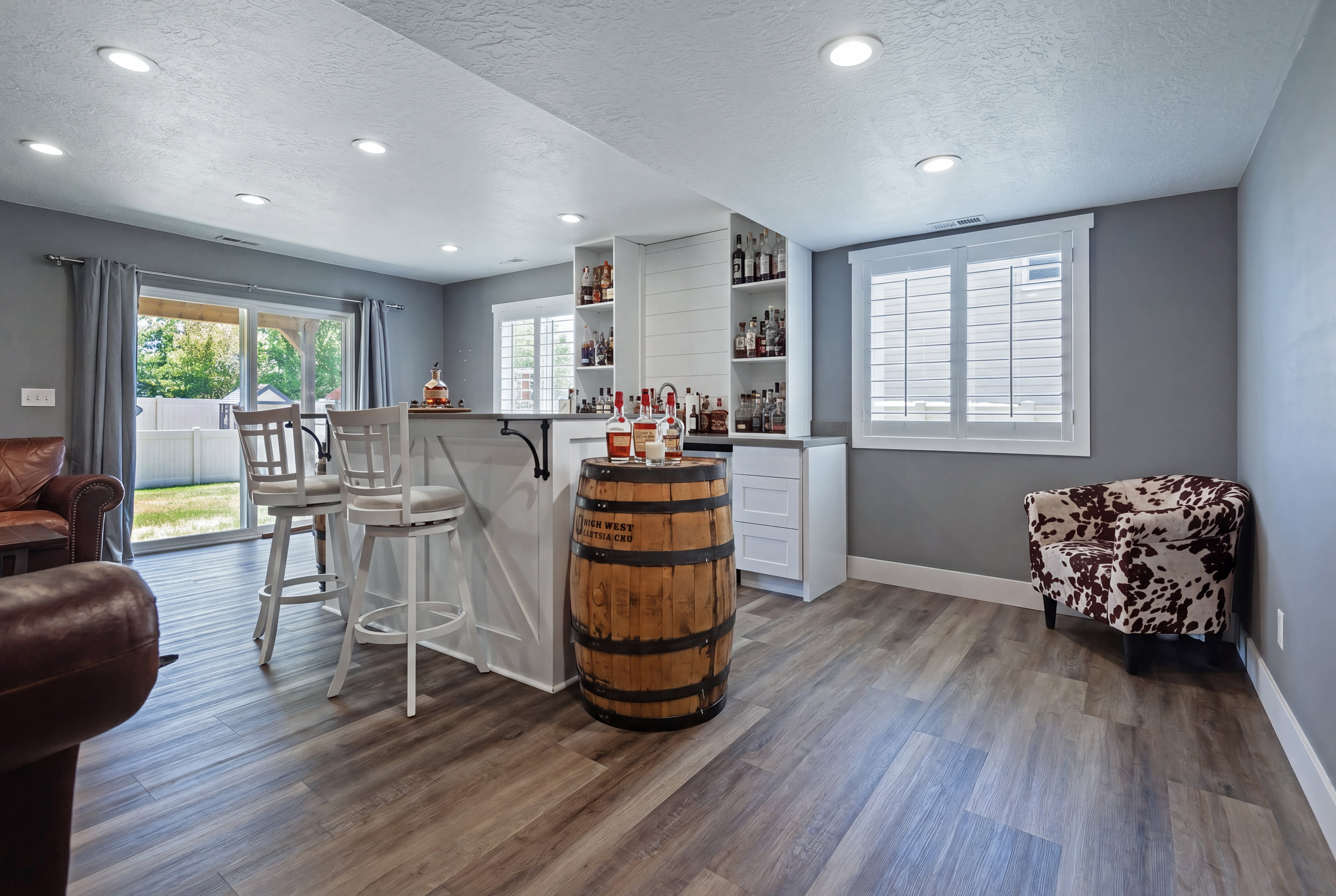 Entertainment space featuring wood-finish flooring, recessed lighting, and a built-in bar with white cabinetry and shelving