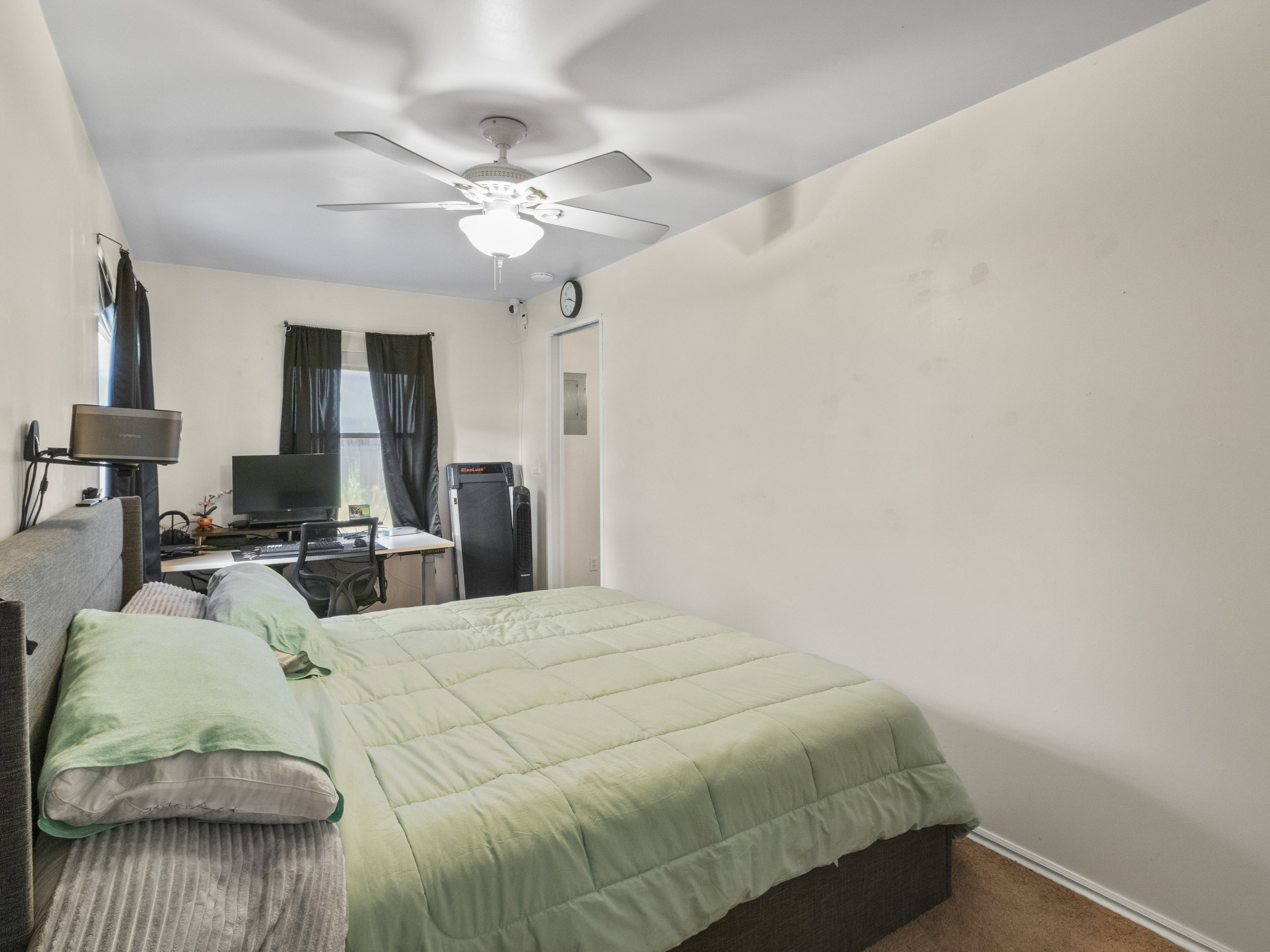 Neutral wall finishes complement the ceiling fan with integrated lighting