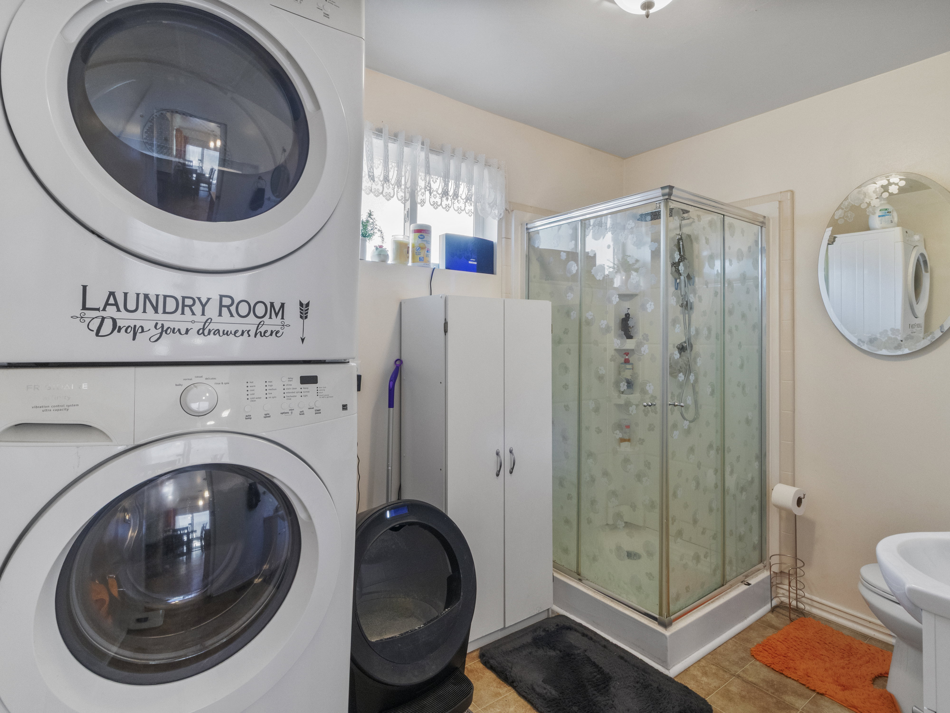 Integrated laundry area featuring stacked appliances
