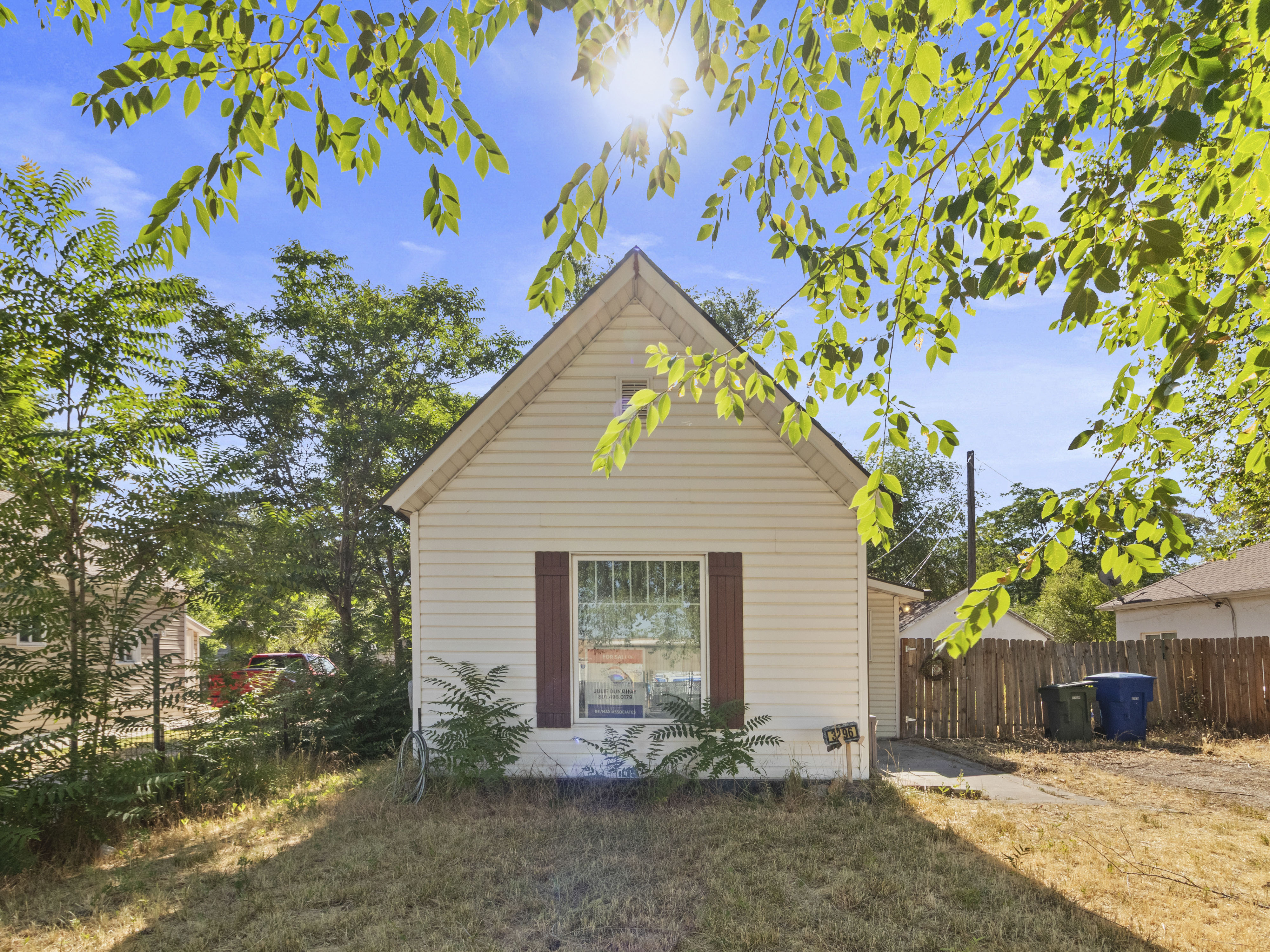 Single-story residence featuring light-colored siding and a gabled roofline
