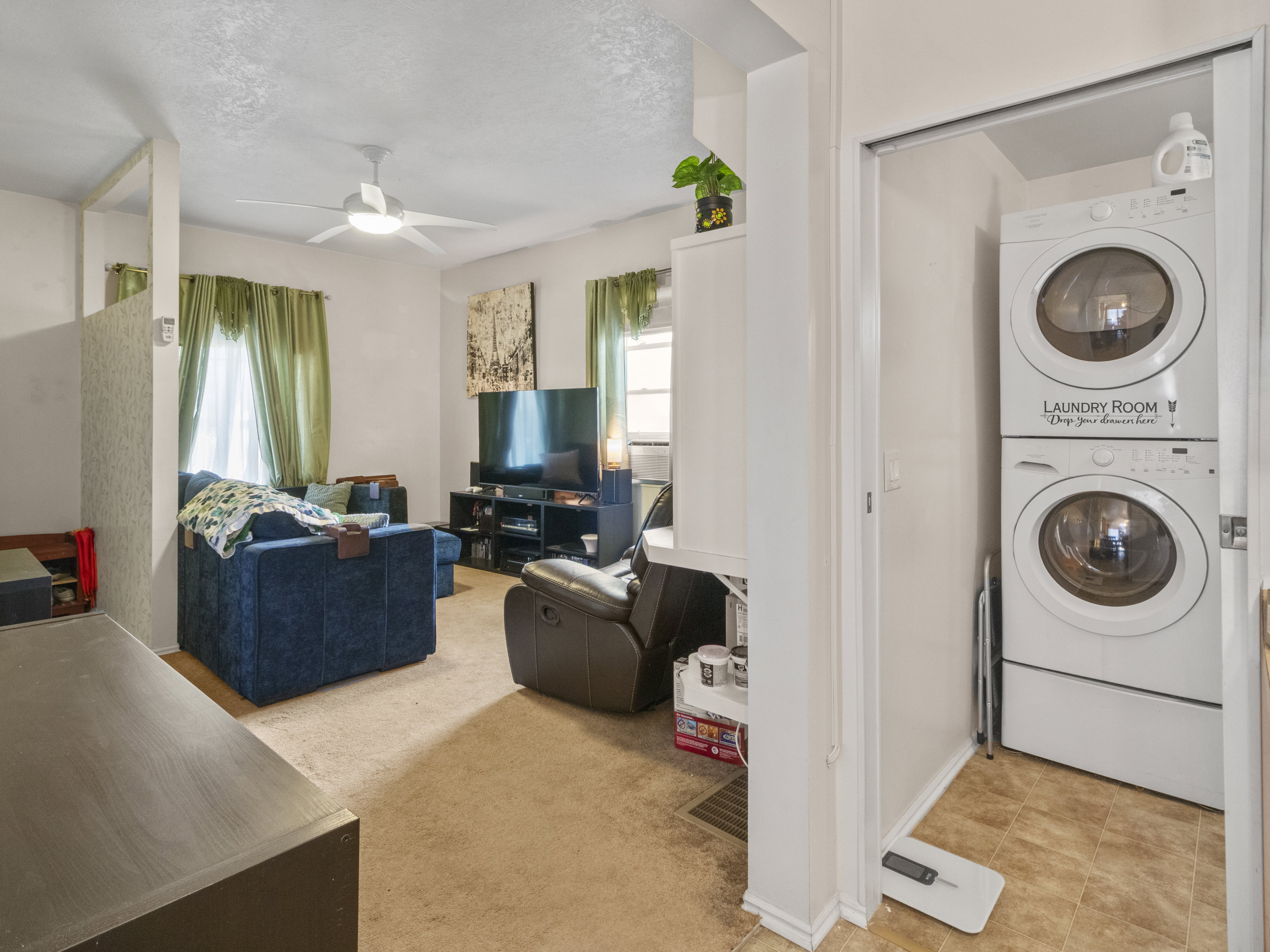 Dedicated laundry closet featuring a stacked washer and dryer unit