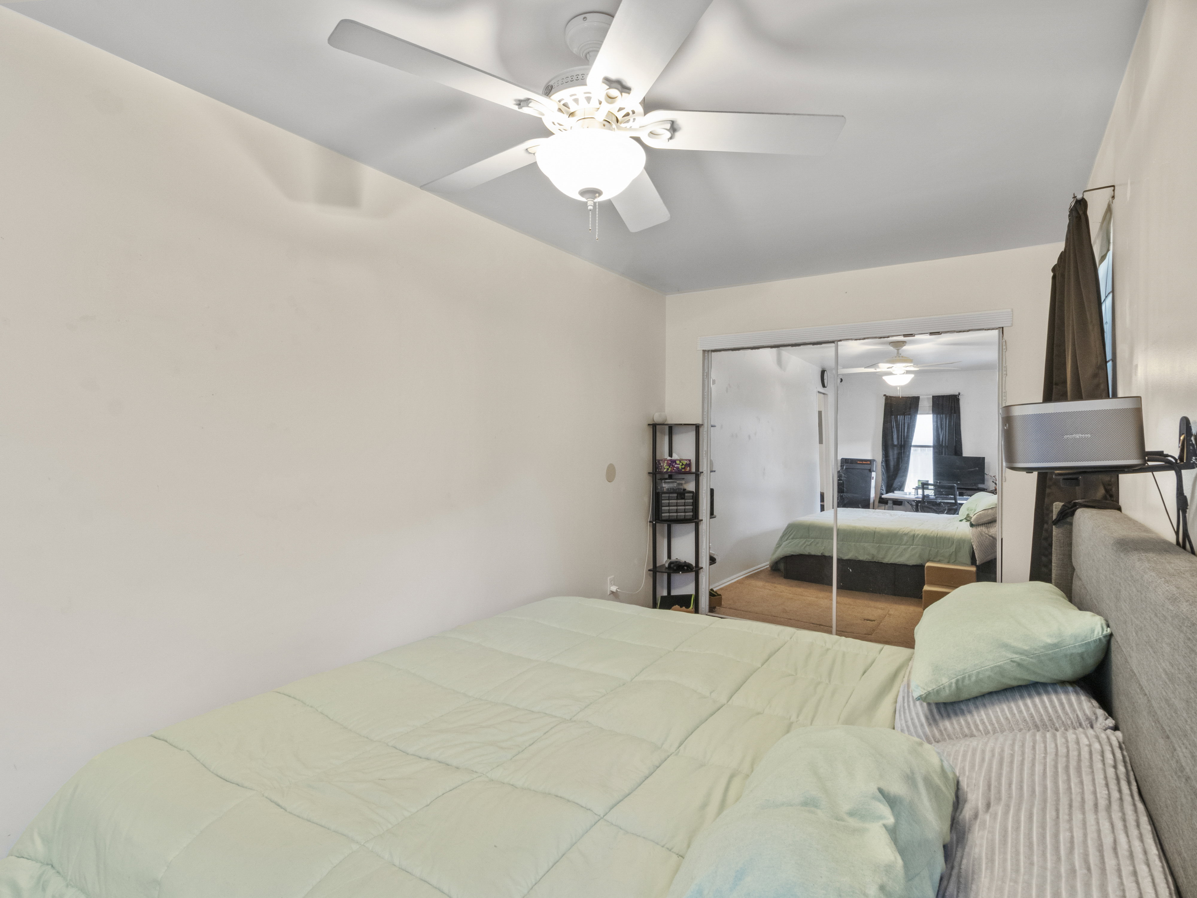 Room featuring a ceiling fan with integrated lighting, mirrored sliding closet doors, and light-toned wall paint