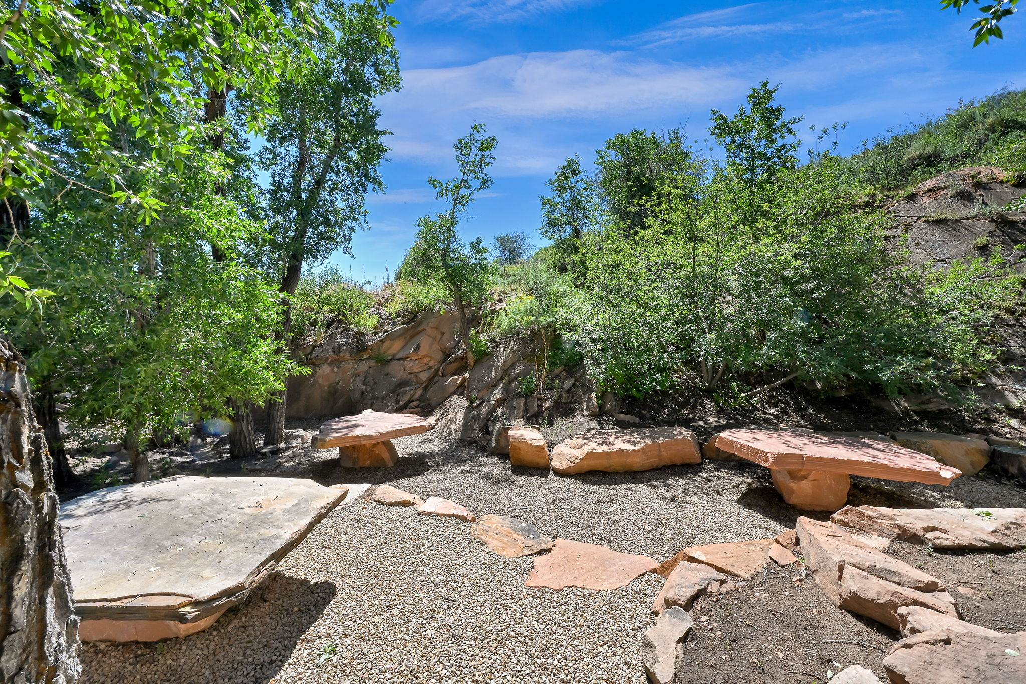 Outdoor area featuring natural rock formations and mature trees