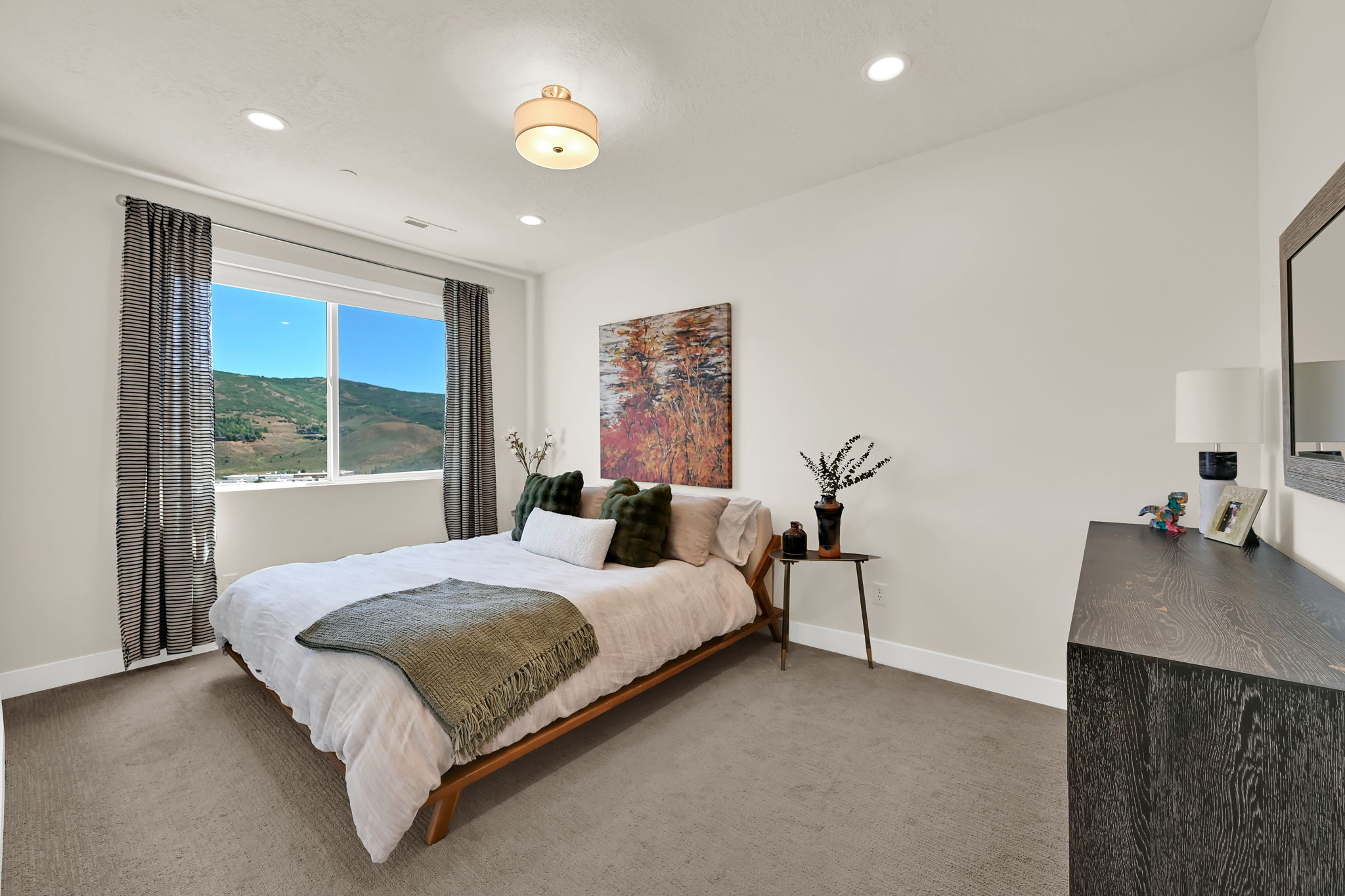 Expansive window framing mountain scenery, complemented by recessed lighting and a central ceiling fixture