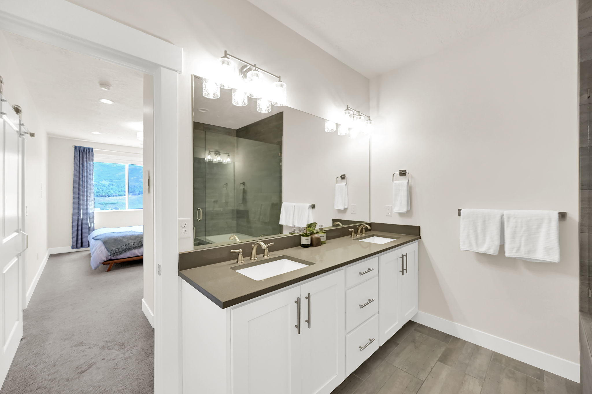 Double vanity with integrated sinks, dark stone countertop, and brushed nickel fixtures