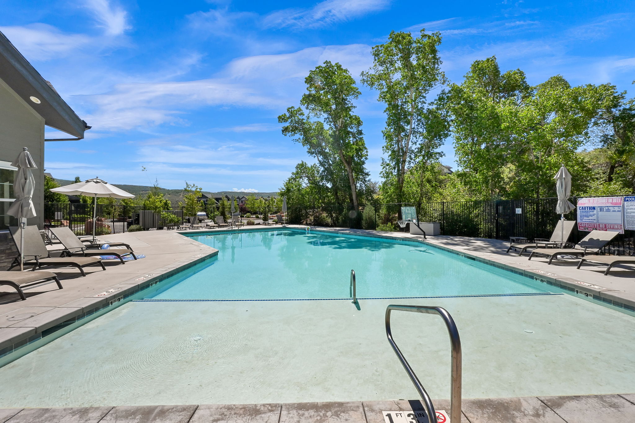 Expansive outdoor swimming pool with surrounding concrete decking