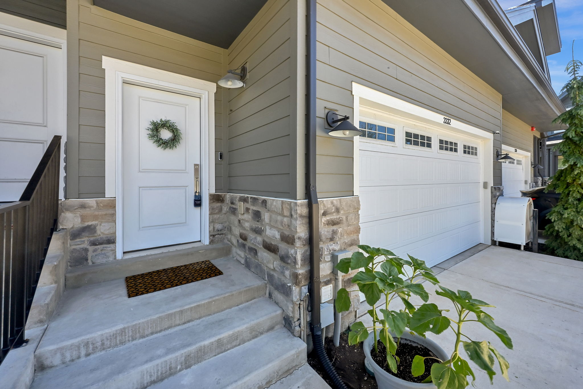 Entryway featuring a white paneled door with sidelight, stone veneer detailing, and concrete steps
