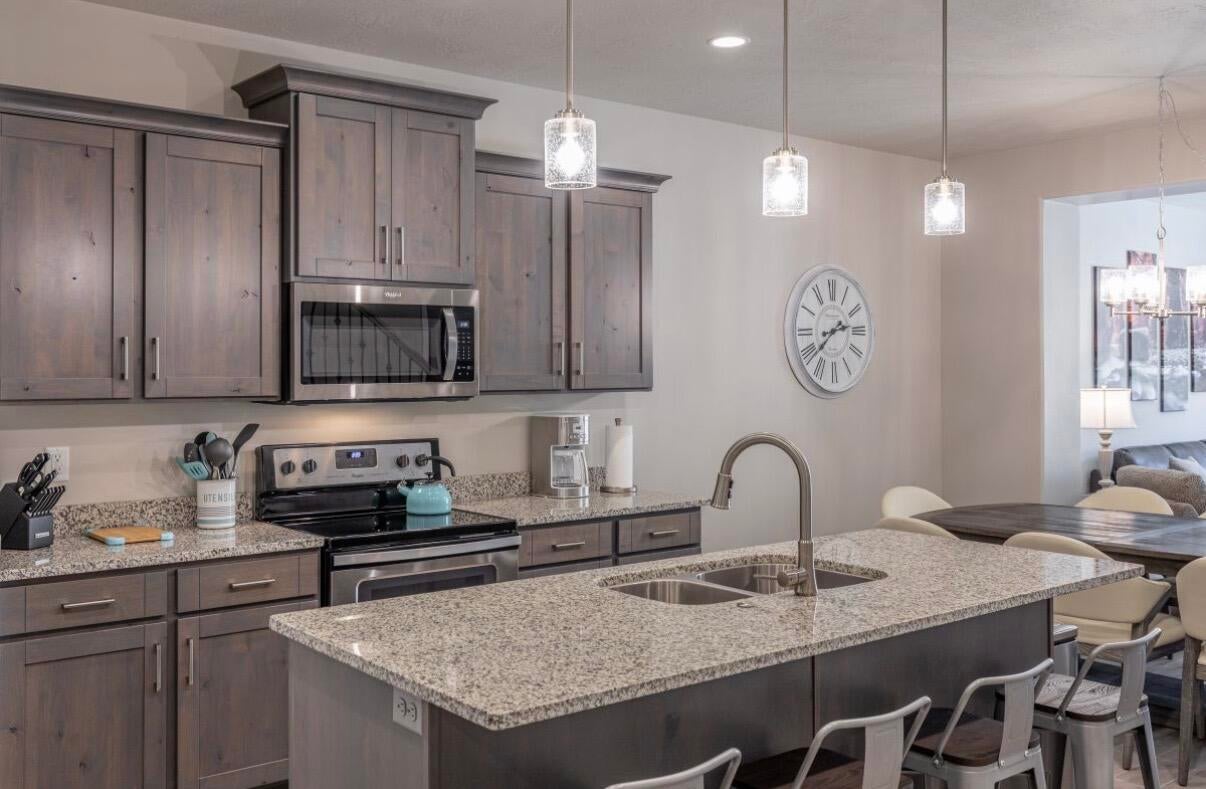 Kitchen featuring wood-finish cabinetry, stainless steel appliances, and granite countertops