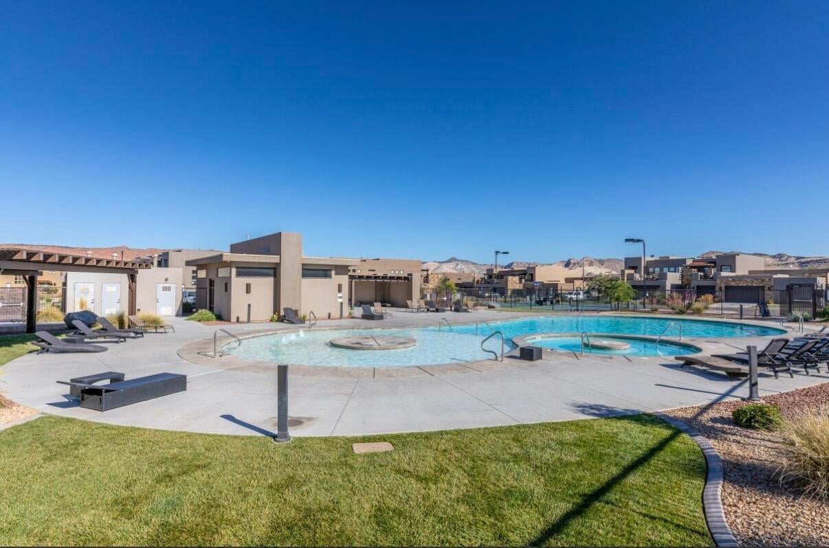 Expansive outdoor swimming pool with integrated spa and surrounding concrete decking