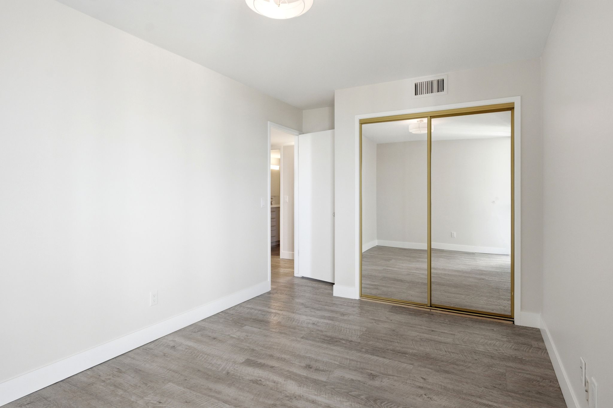 Bright interior space featuring wood-finish flooring, white walls, and a recessed ceiling light