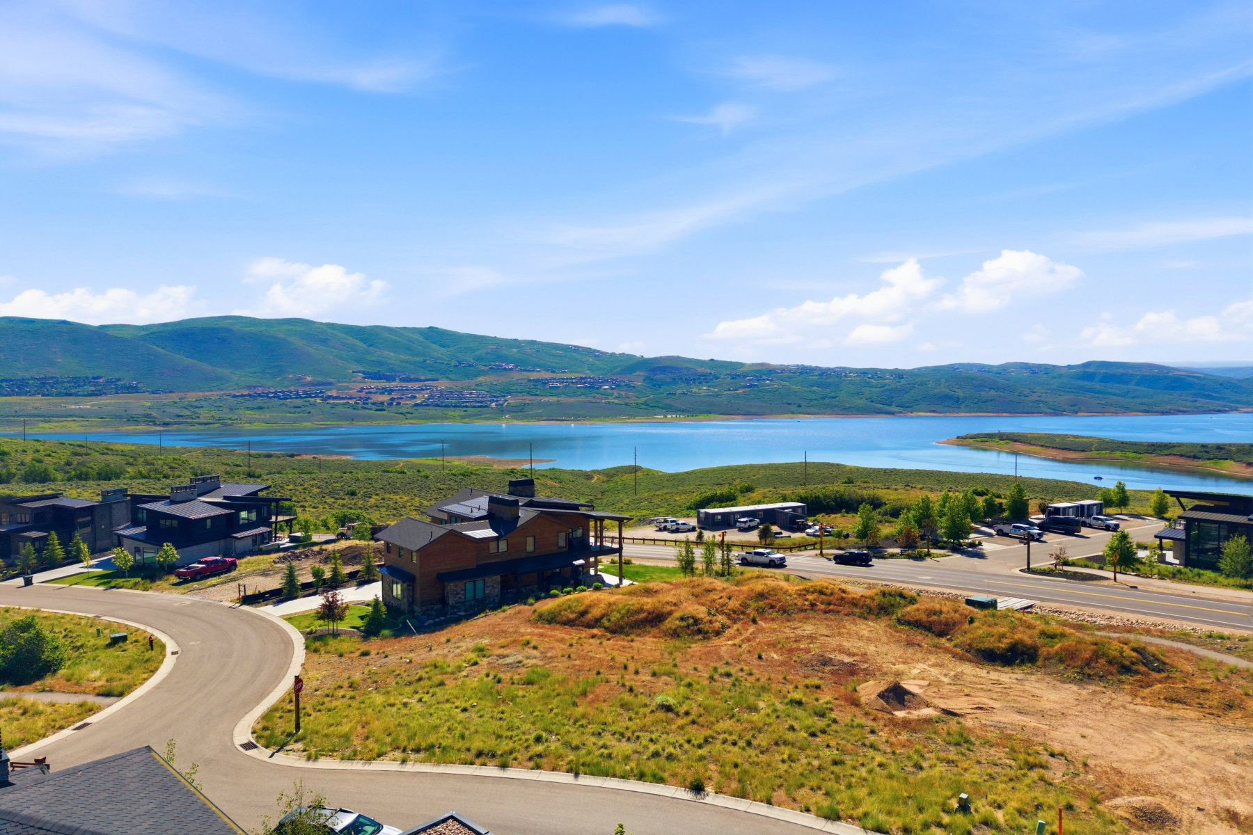 Aerial perspective showcasing a large body of water, distant mountains, and surrounding properties