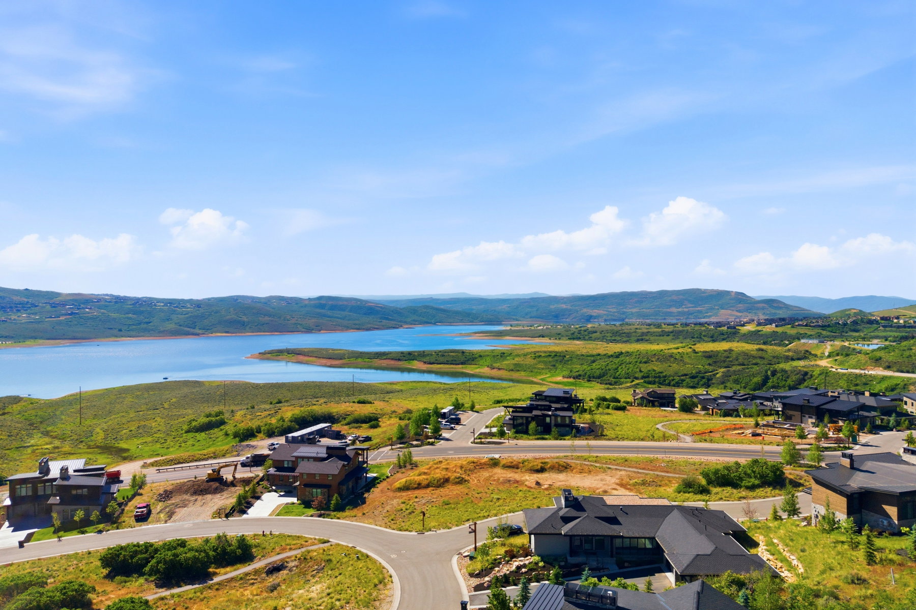 Expansive water body surrounded by lush green and golden hillsides