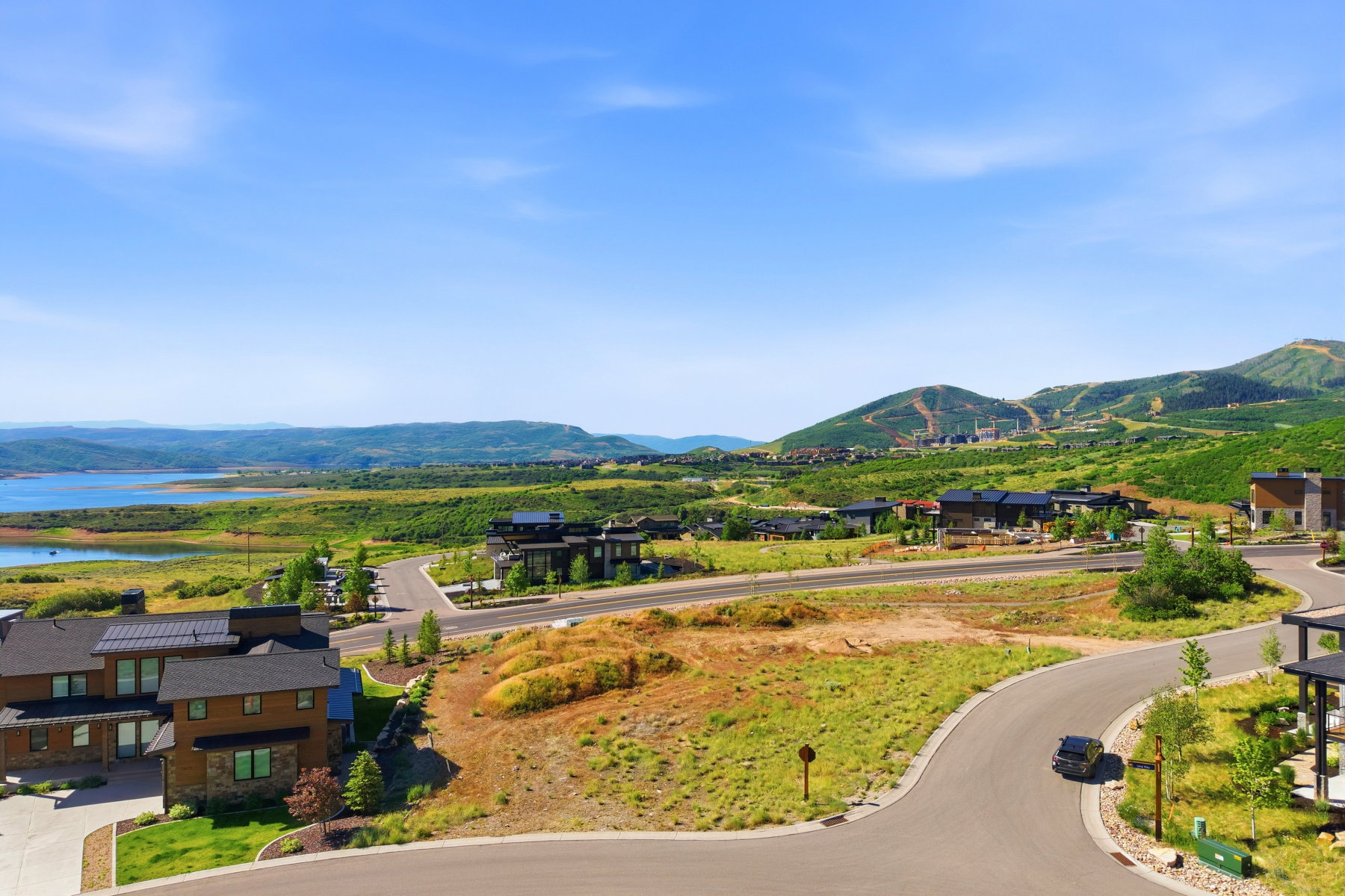 Expansive mountain and lake landscape featuring multiple contemporary residences
