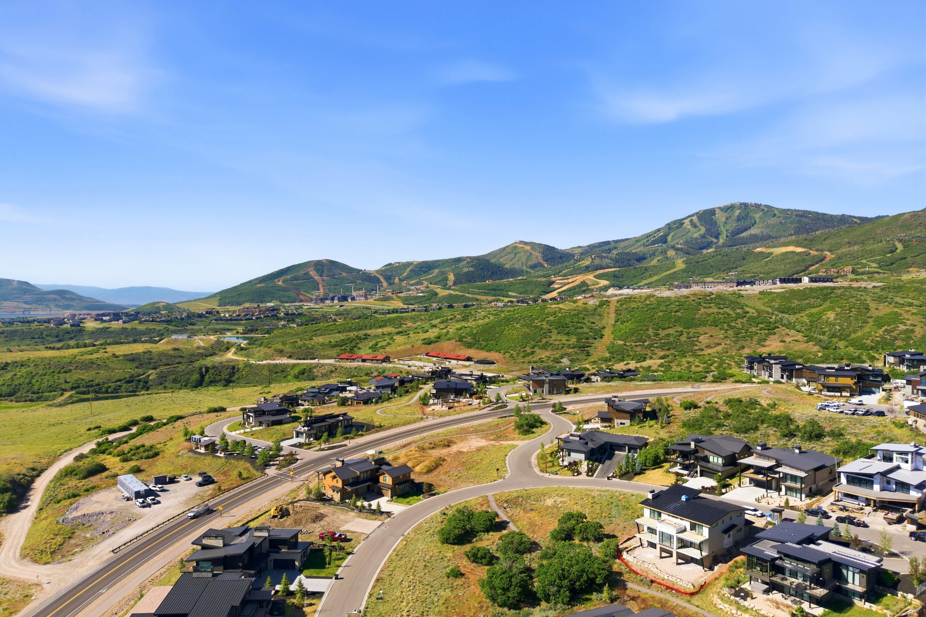 Aerial representation of the expansive mountain landscape featuring residential properties set amidst rolling green hills