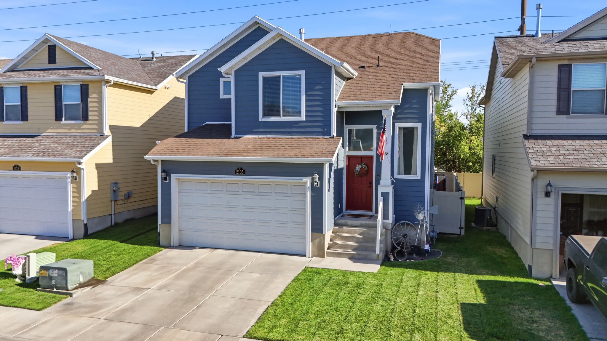 Blue siding exterior with white trim details and a contrasting red front door