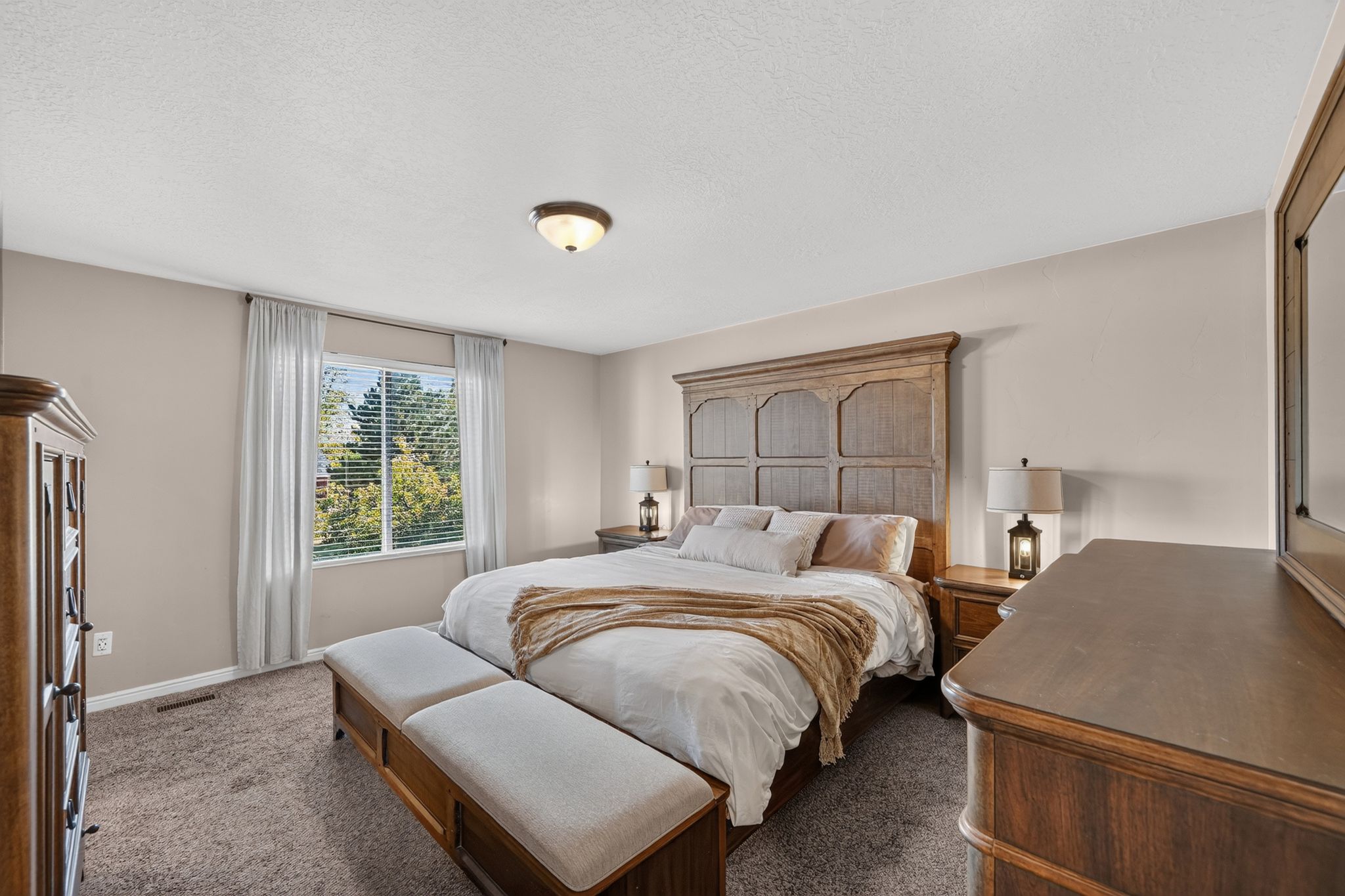 Carpeted bedroom featuring neutral wall tones and a window with white blinds