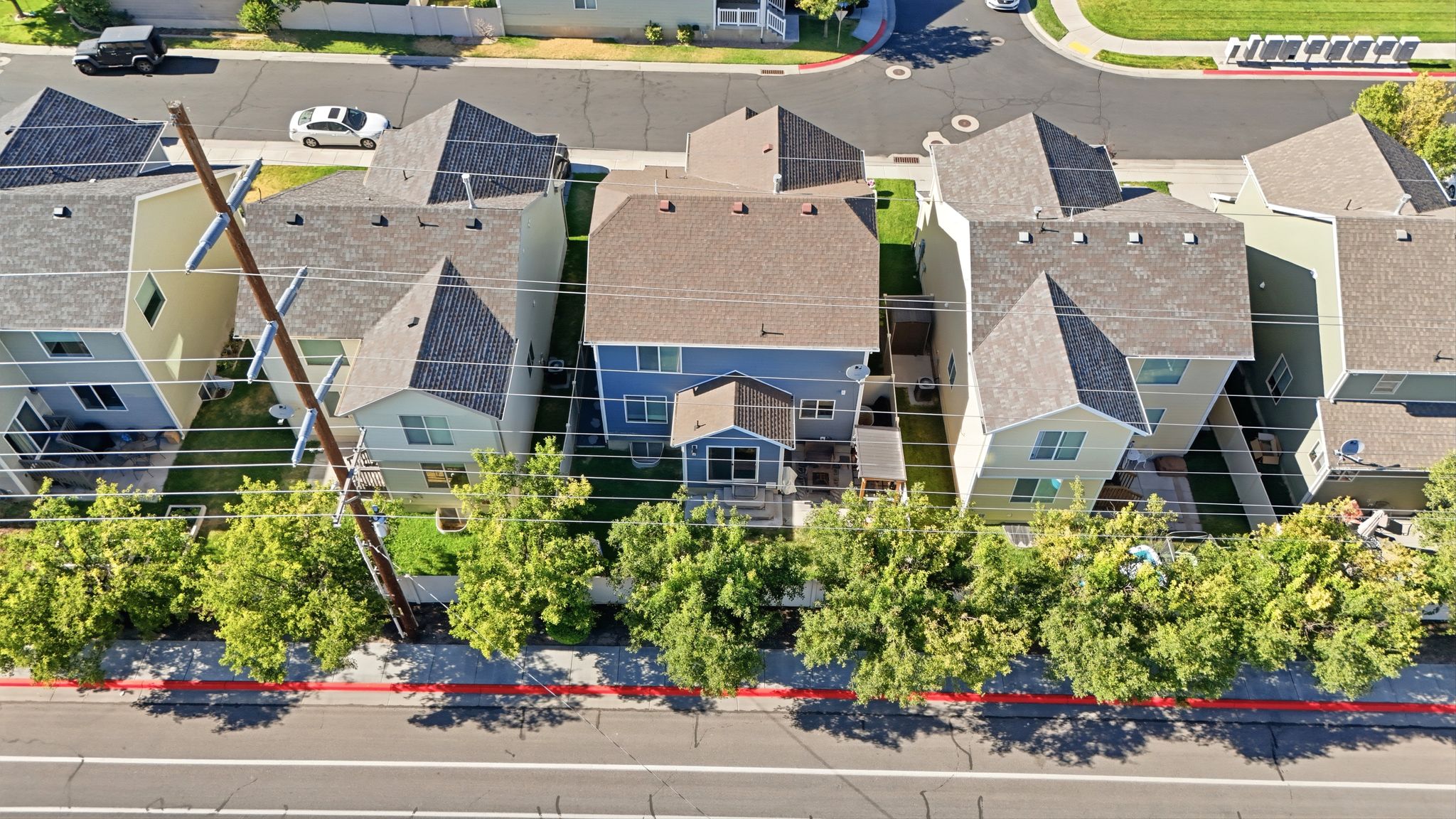 Aerial perspective of a residential street with multiple properties featuring asphalt shingle roofs and two-story elevations