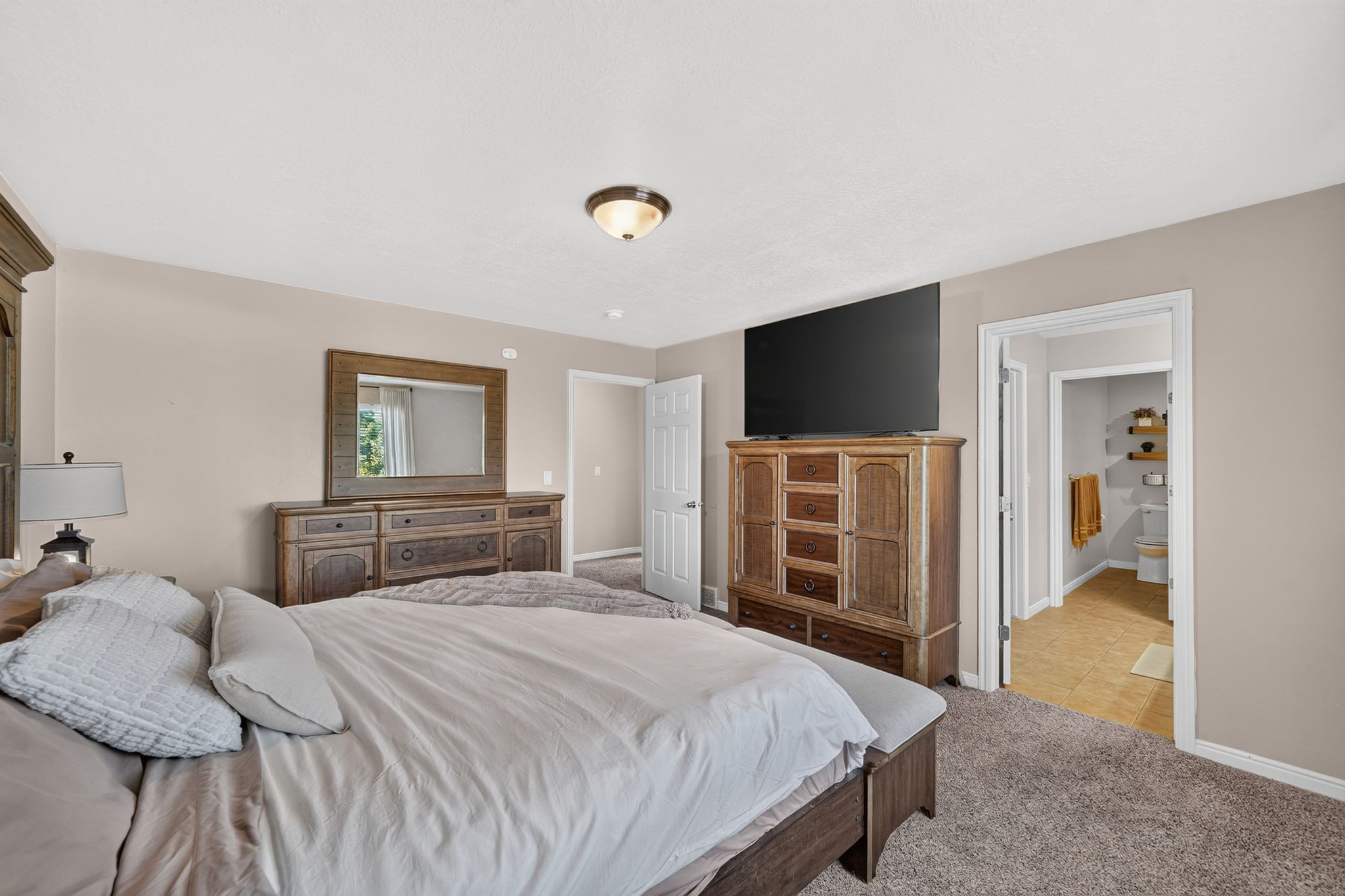 Spacious room with neutral wall tones and textured carpeting
