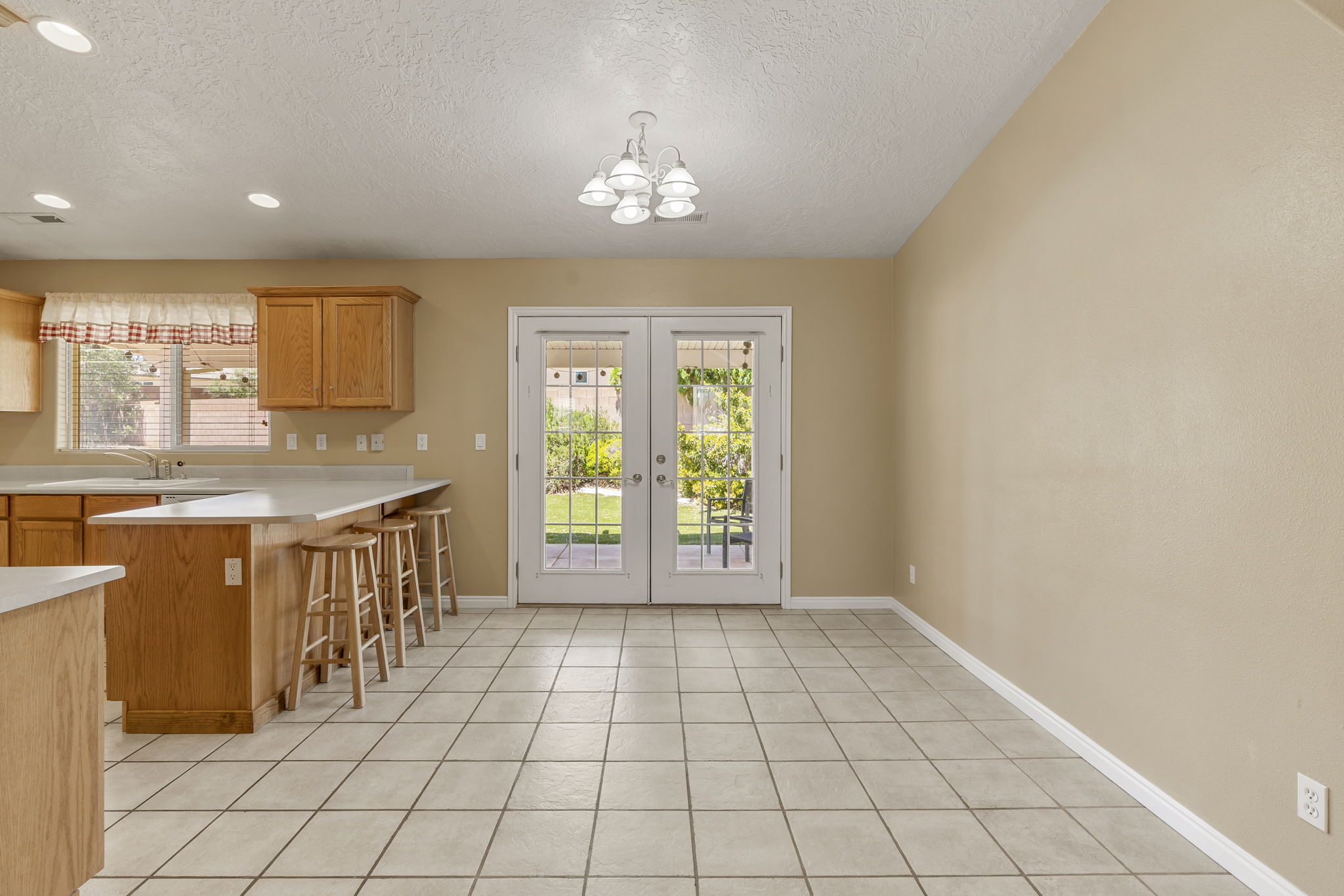 Kitchen and dining area featuring wood cabinetry, light countertops, and tile flooring