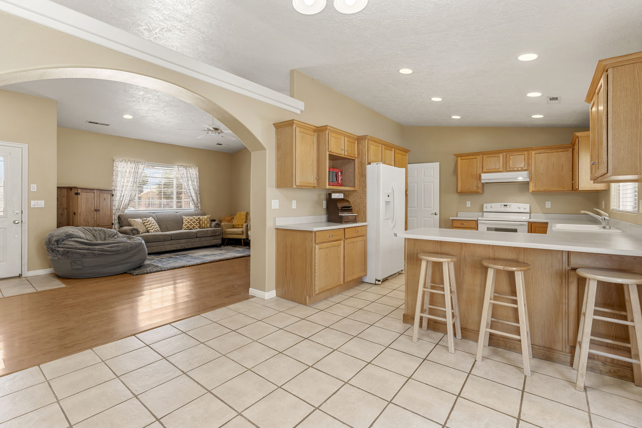 Kitchen featuring light wood cabinetry, white countertops, tile flooring, and a breakfast bar