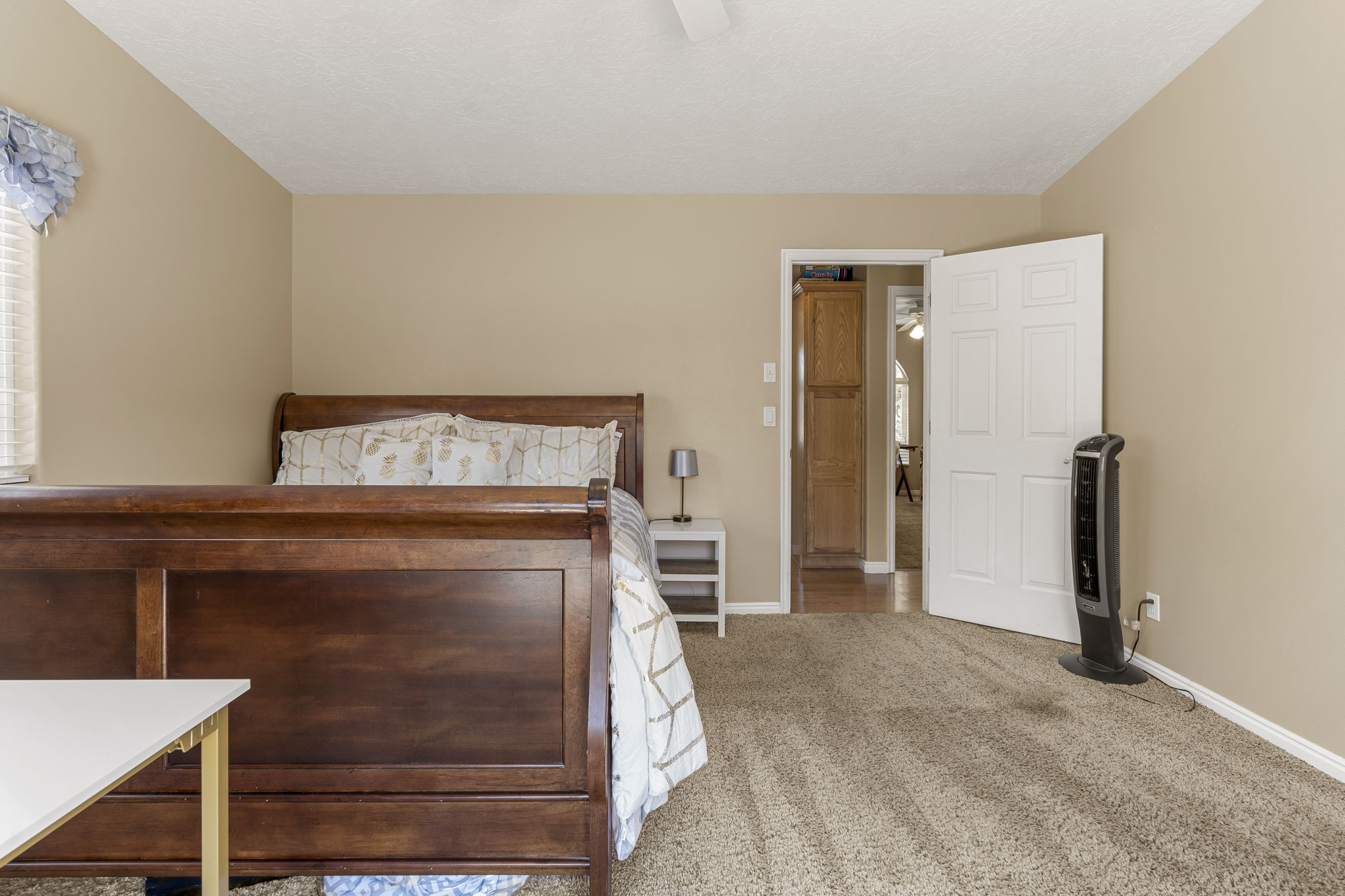 Room featuring light tan wall paint and textured carpet flooring