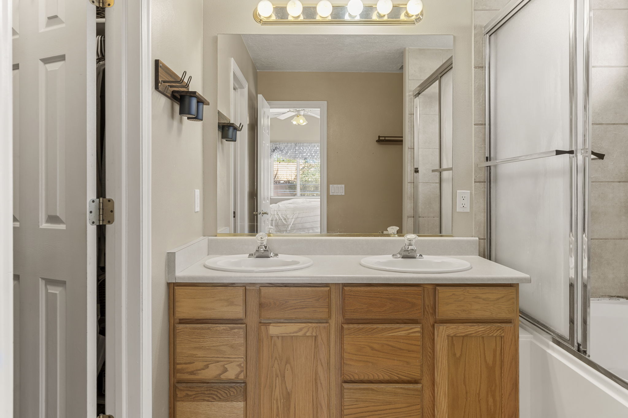 Bathroom featuring a double vanity with light wood cabinetry and a light-colored countertop