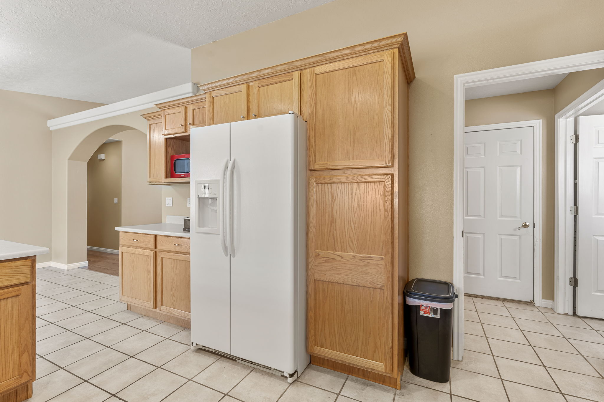 Kitchen featuring extensive wood cabinetry, light countertops, and tile flooring