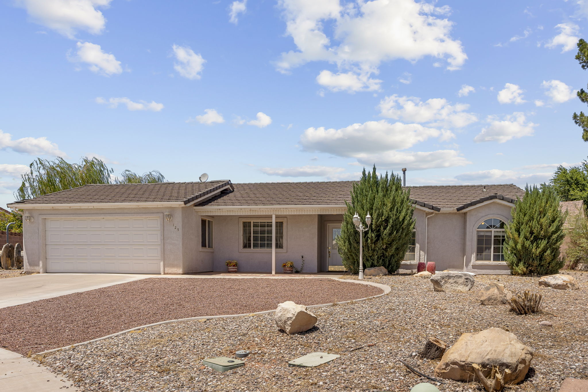 Single-story residence featuring a two-car garage, a low-maintenance gravel and rock front yard, and a covered entry
