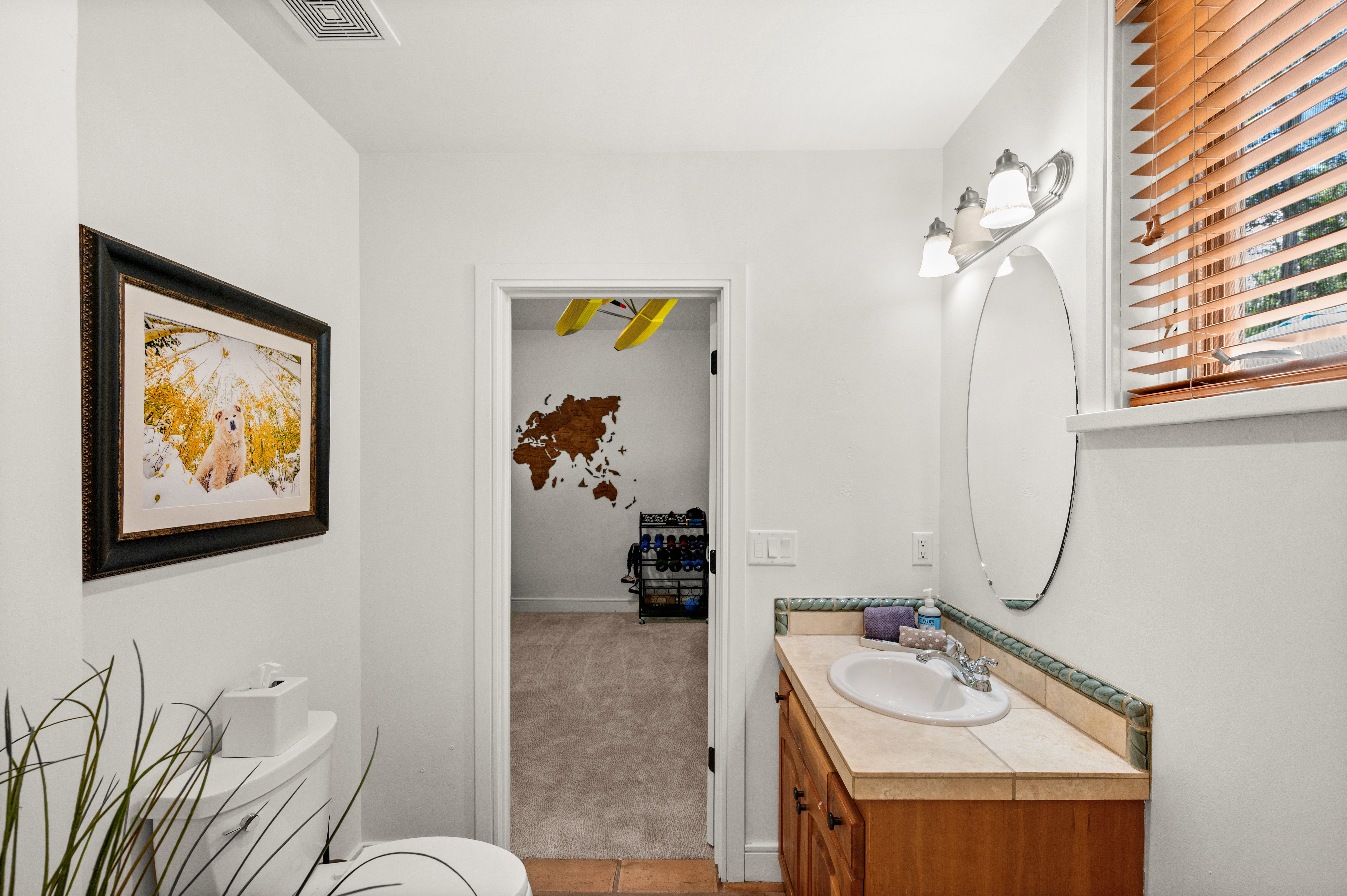 Bathroom vanity featuring a tiled countertop with an integrated sink and wood cabinetry