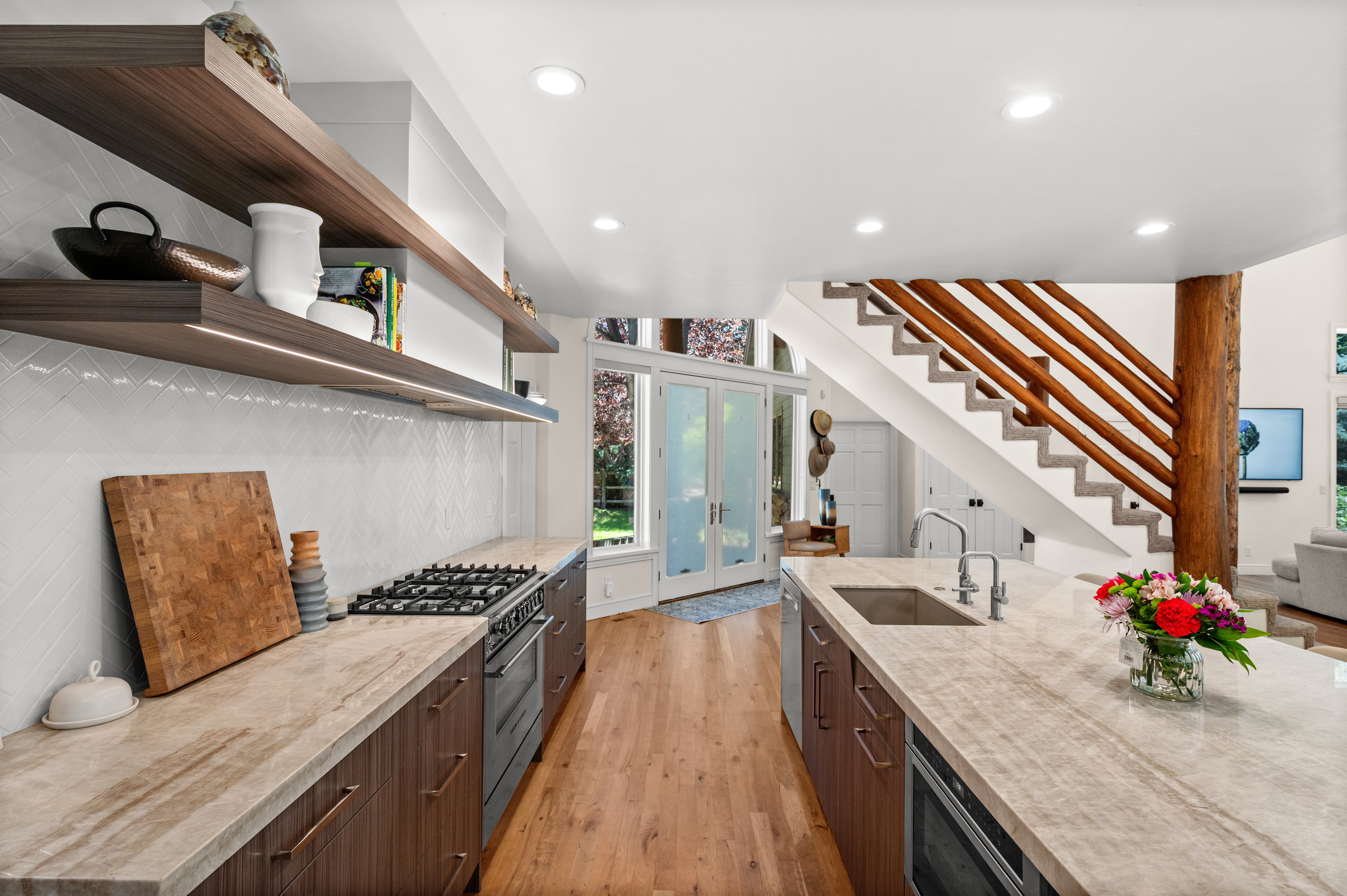 Gourmet kitchen featuring a built-in gas range, integrated double oven, and a large central island with an undermount sink