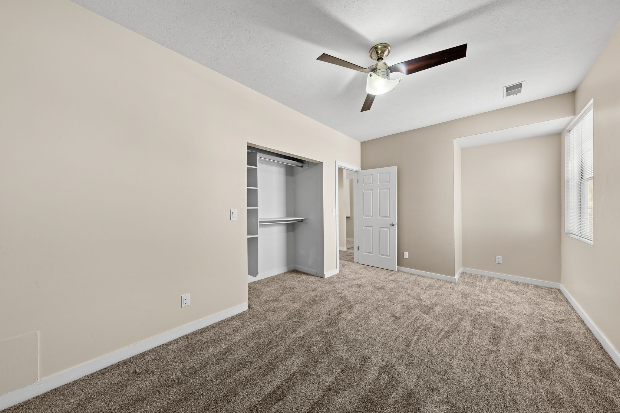 Carpeted room with neutral wall tones and white trim