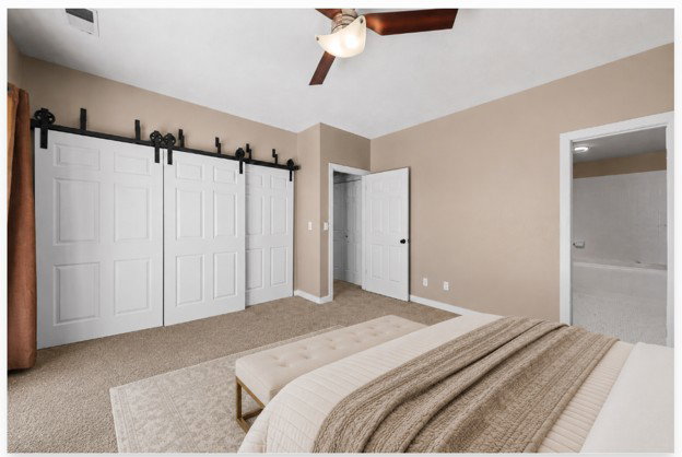 Bedroom featuring neutral-toned walls, plush carpeting, and a ceiling fan with integrated lighting