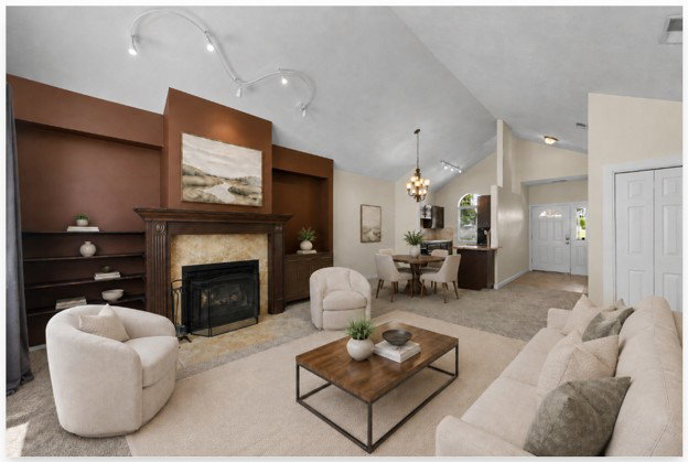 Living area with a vaulted ceiling, track lighting, and a fireplace featuring a wood mantel and stone surround