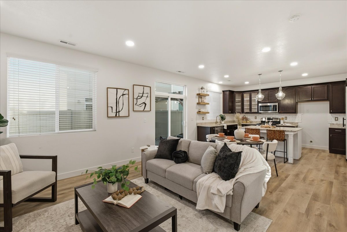 Open-concept living space featuring wood-finish flooring, recessed lighting, and a sliding glass door