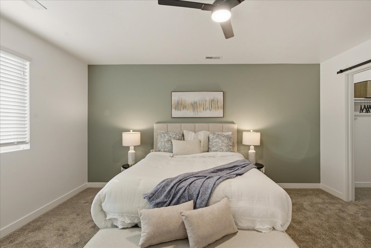 Bedroom featuring carpet flooring, a window with horizontal blinds, and a ceiling fan with integrated lighting