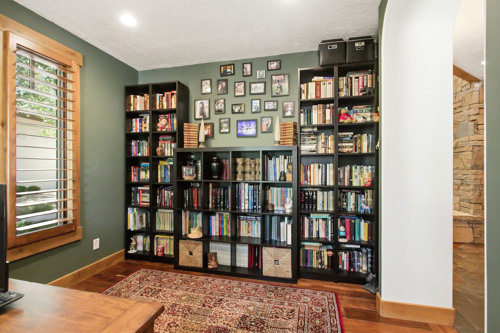 Room featuring wood-finish flooring, recessed lighting, and a window with plantation shutters
