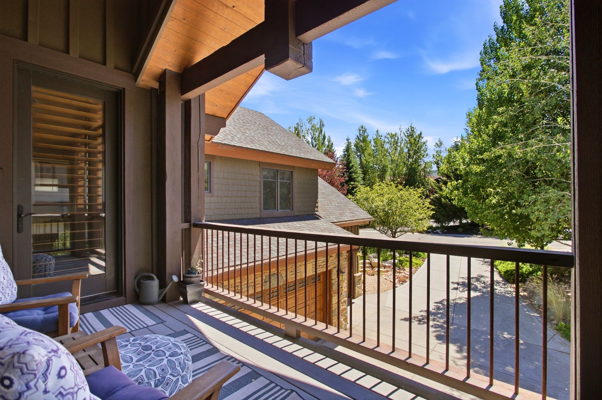 Covered balcony featuring wood-finish ceiling, vertical siding, a door with internal blinds, and a metal railing
